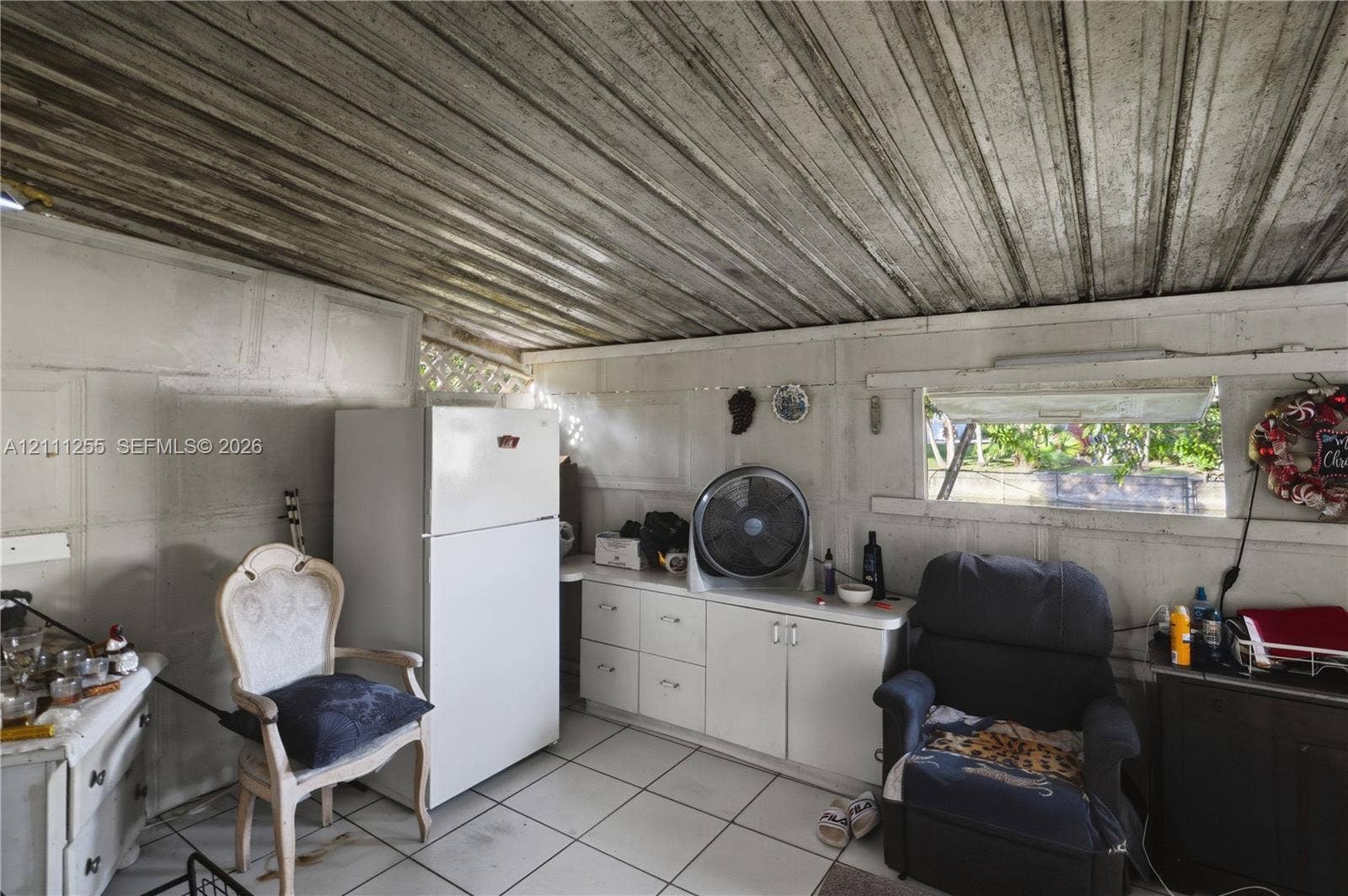 Enclosed space featuring tile flooring, built-in cabinetry, and a top-mount refrigerator