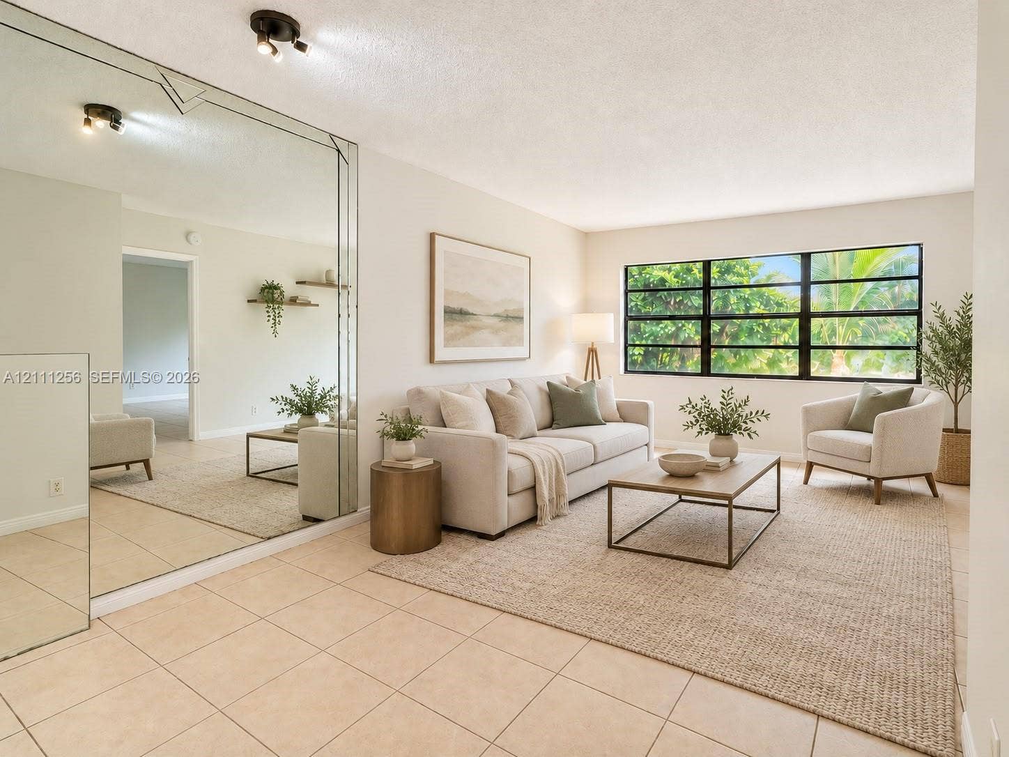 Living area featuring neutral tile flooring, large multi-pane windows with black frames, and a floor-to-ceiling mirrored wall