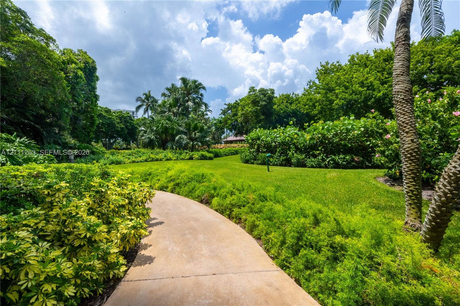 4000 Towerside Terrace, #604, Miami, FL 33138 Manicured lawn, paved walkway, mature palms, and extensive landscaping