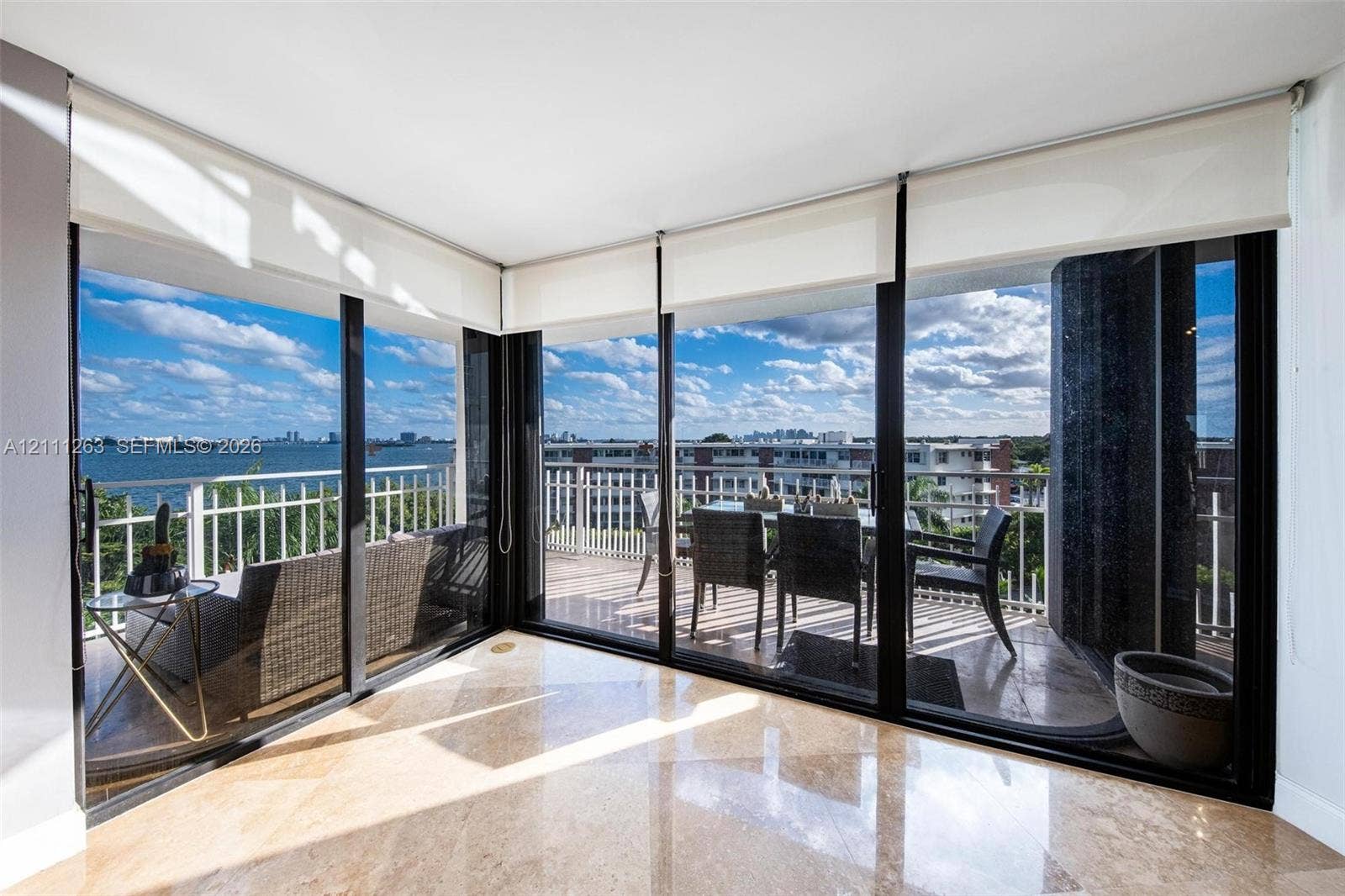 4000 Towerside Terrace, #604, Miami, FL 33138 Floor-to-ceiling glass walls, polished stone flooring, and expansive wrap-around balcony with white metal railings