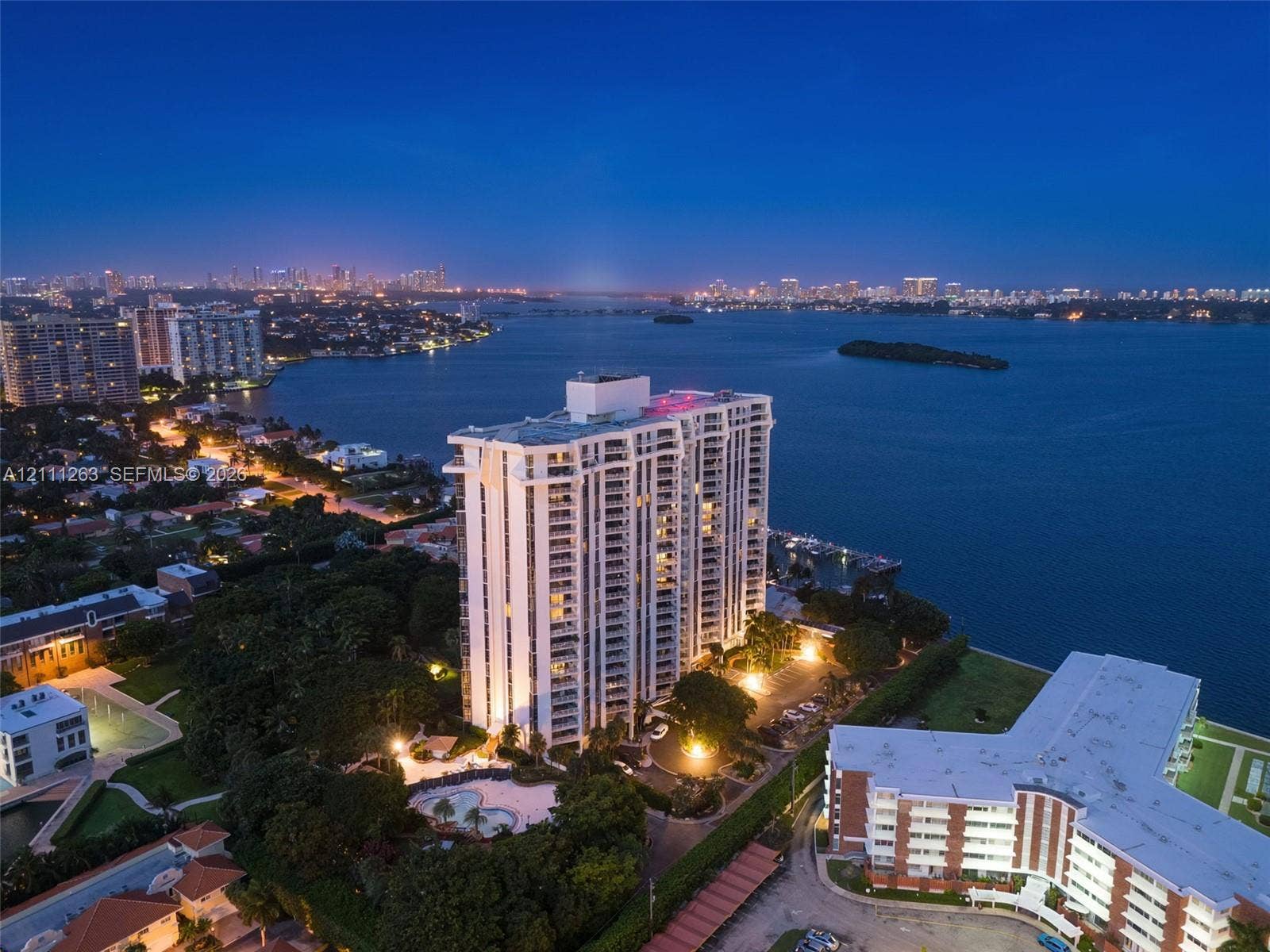 4000 Towerside Terrace, #604, Miami, FL 33138 High-rise residential tower featuring a waterfront location, balconies, and an outdoor swimming pool set within landscaped grounds
