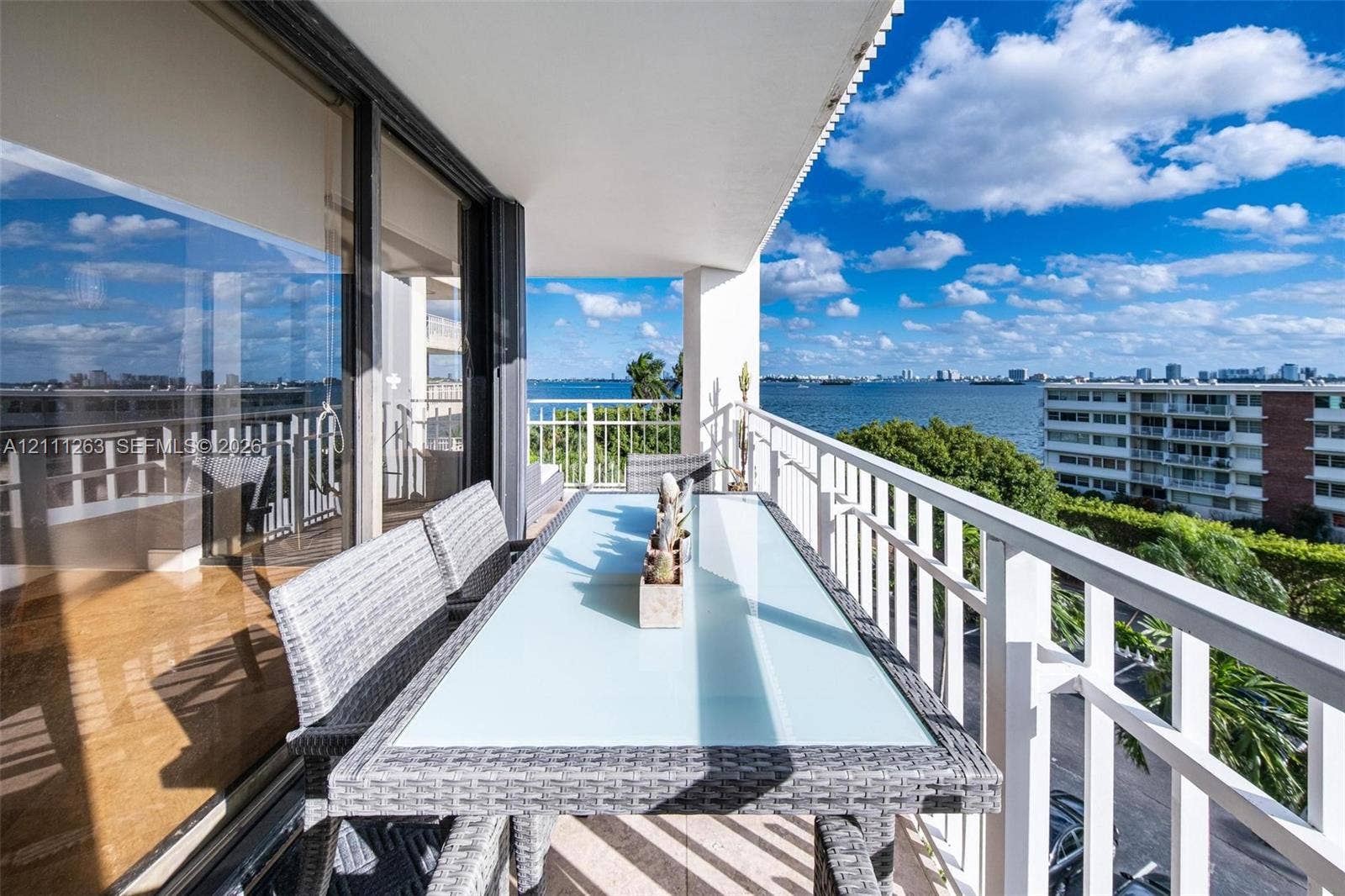 4000 Towerside Terrace, #604, Miami, FL 33138 Covered balcony featuring white metal railings, tile flooring, and floor-to-ceiling glass sliding doors