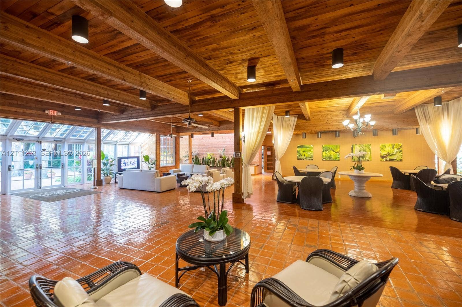 4000 Towerside Terrace, #604, Miami, FL 33138 Expansive interior space featuring exposed wood-beam ceilings, clay tile flooring, and floor-to-ceiling glass panel walls