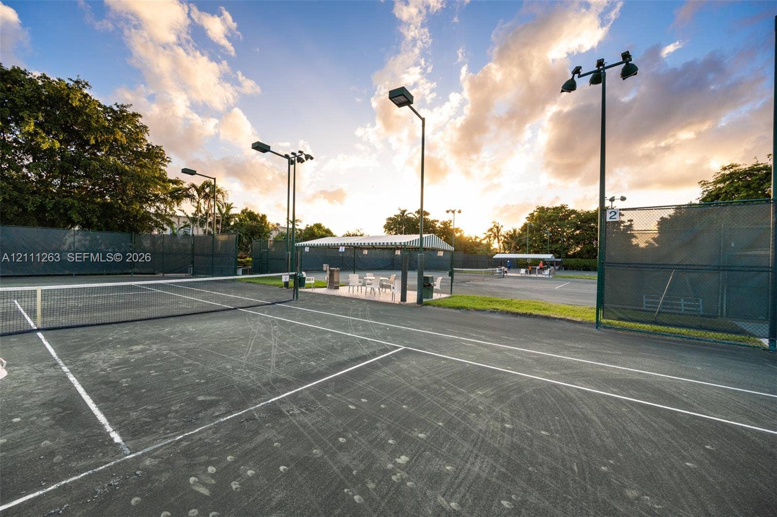 4000 Towerside Terrace, #604, Miami, FL 33138 Hard-surfaced tennis court featuring perimeter fencing, overhead lighting fixtures, and a covered pavilion