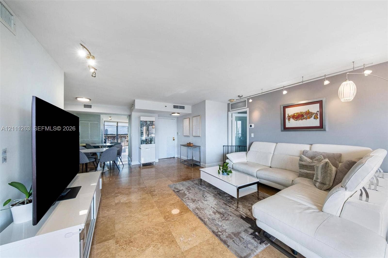 4000 Towerside Terrace, #604, Miami, FL 33138 Open-concept living space featuring large-format tile flooring, track lighting, and a neutral color palette