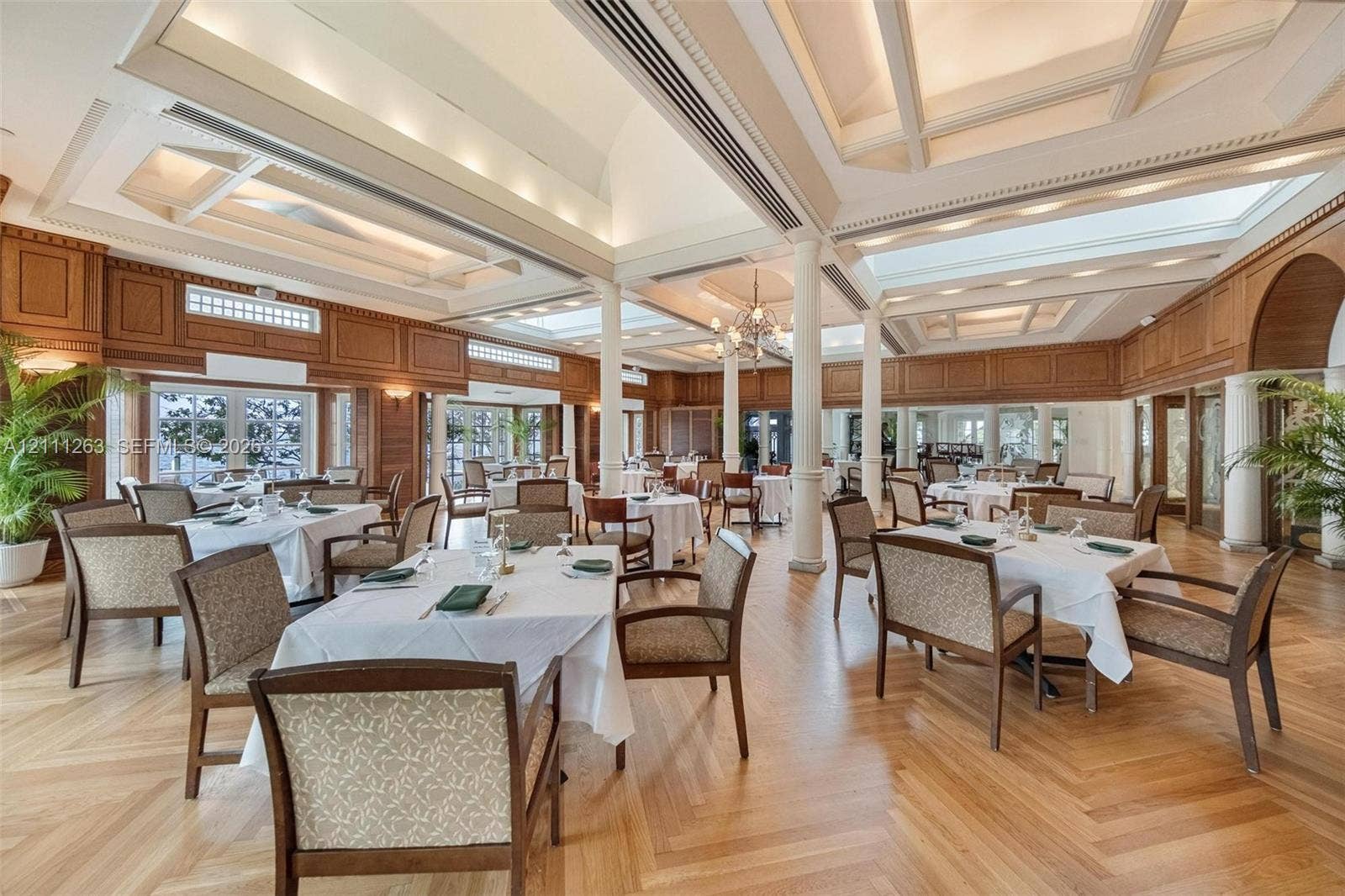 4000 Towerside Terrace, #604, Miami, FL 33138 Expansive interior featuring high coffered ceilings with recessed lighting, herringbone wood-finish flooring, custom wood wall paneling, and structural columns
