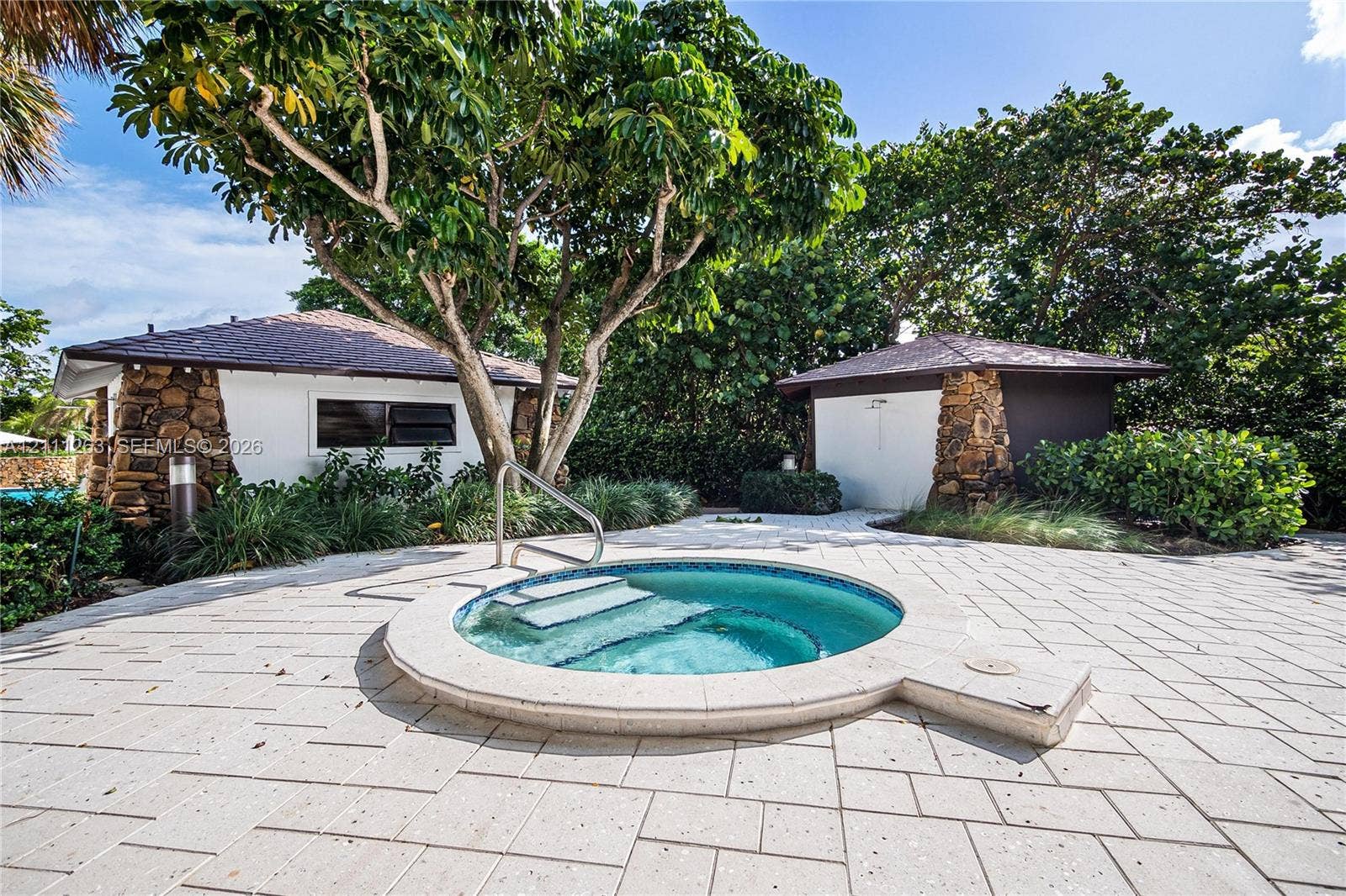 4000 Towerside Terrace, #604, Miami, FL 33138 In-ground spa featuring a circular concrete surround, stone-accented exterior structures, and light-toned paver hardscaping