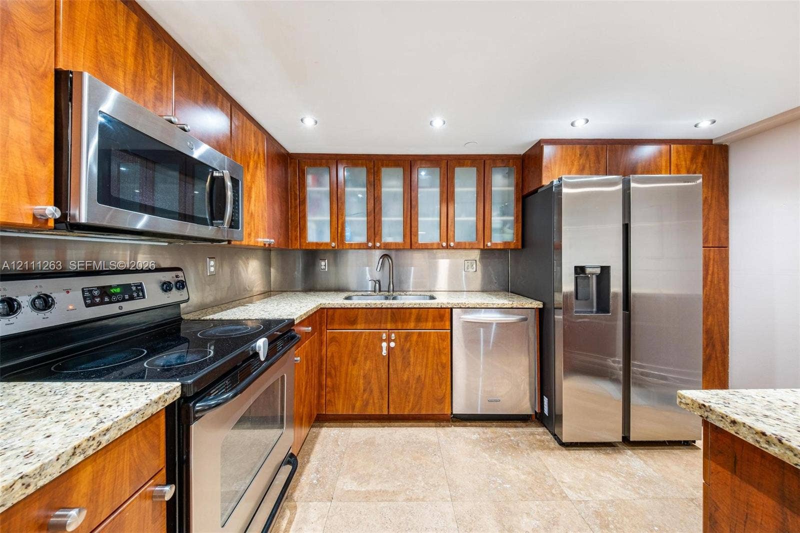 4000 Towerside Terrace, #604, Miami, FL 33138 Kitchen featuring wood cabinetry, stone countertops, stainless steel appliances, glass-front upper cabinets, and recessed lighting