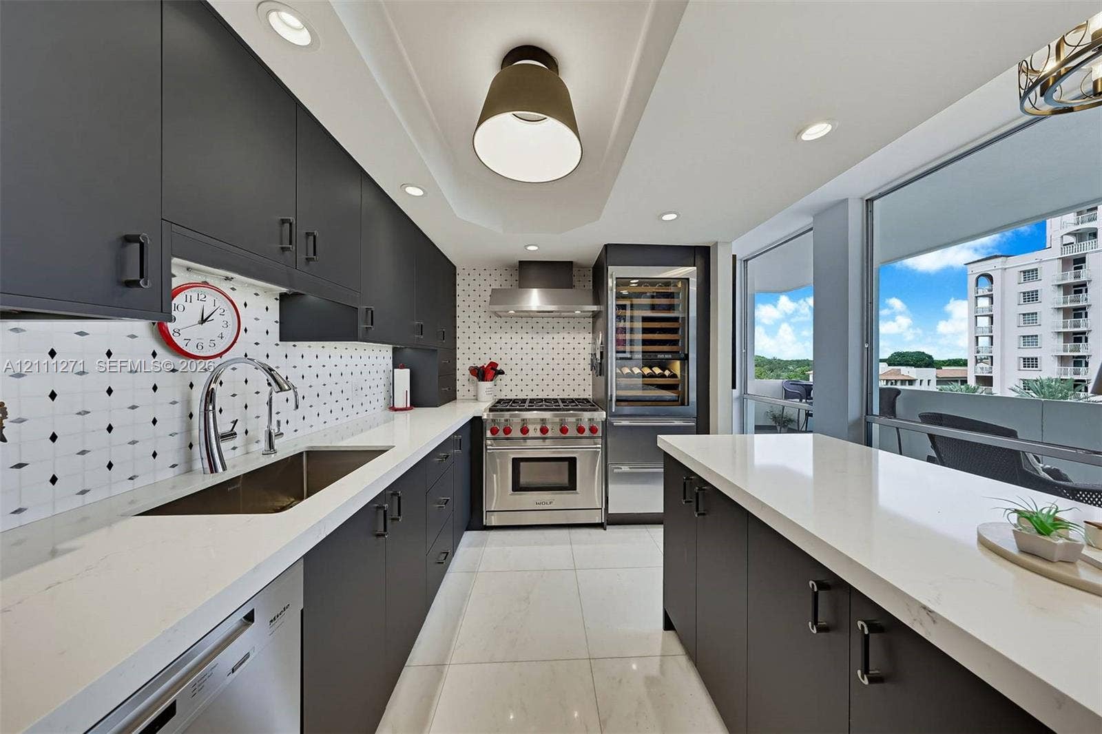 Kitchen featuring matte-finish cabinetry, quartz countertops, geometric patterned tile backsplash, stainless steel gas range, and built-in wine refrigeration