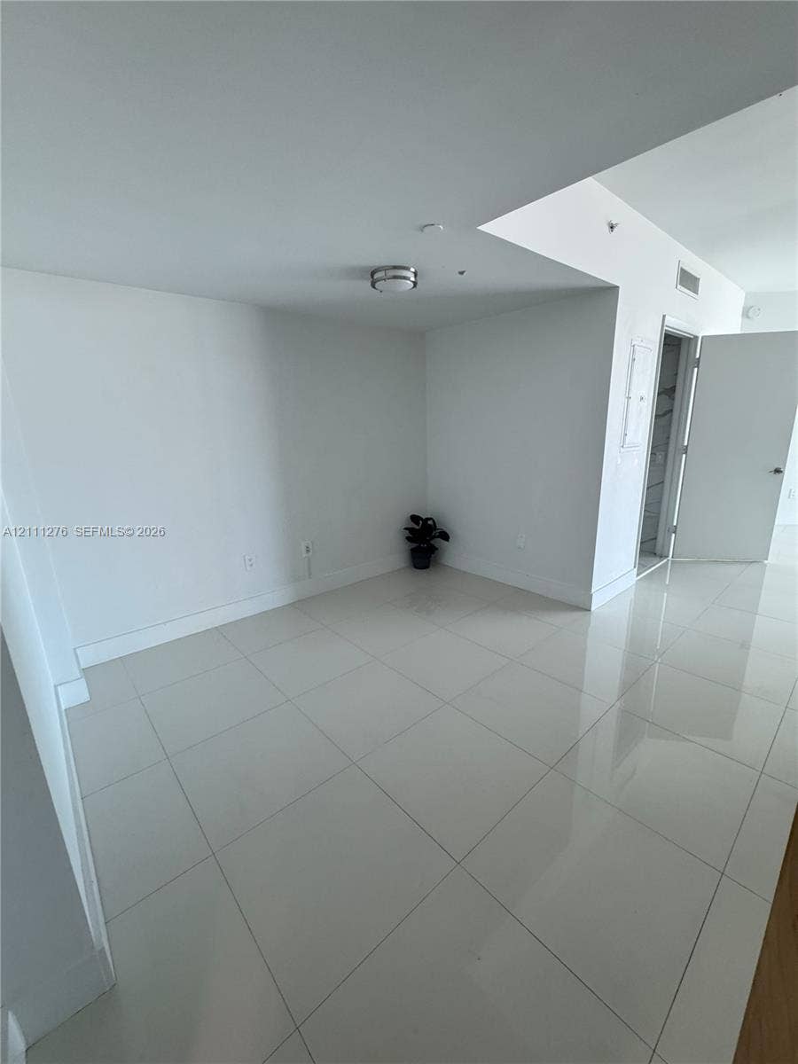 Glossy tile flooring, neutral wall finishes, and flush-mount ceiling lighting