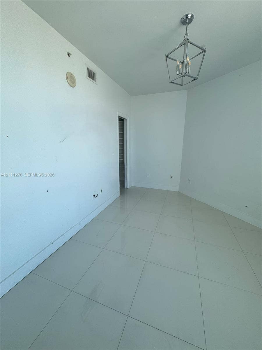 Room featuring large-format ceramic tile flooring and an industrial-style metal geometric chandelier