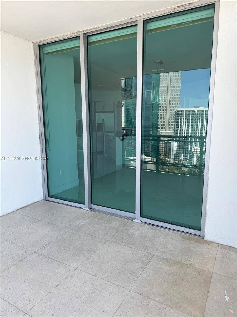 Balcony featuring large-format tile flooring and floor-to-ceiling glass sliding doors with aluminum frames