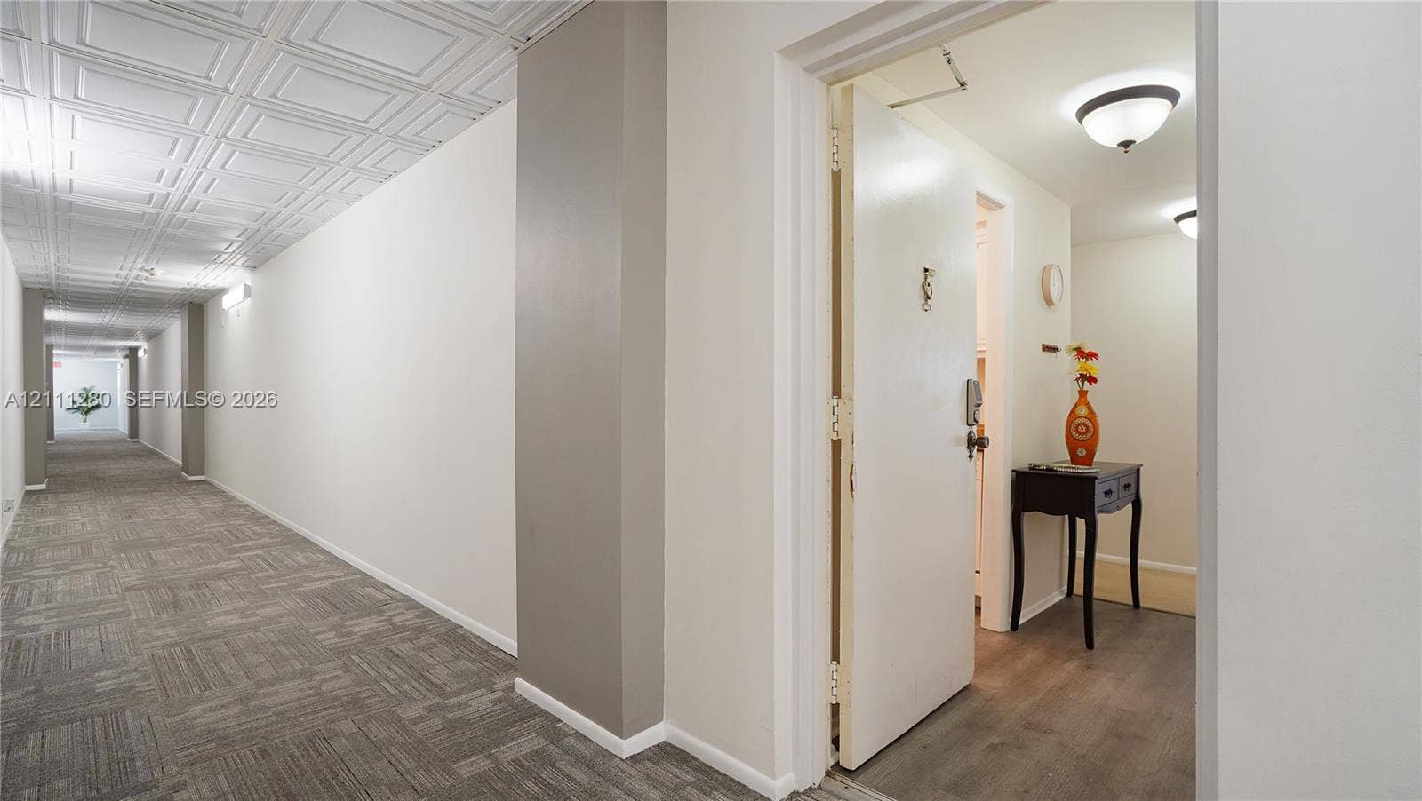 400 N Riverside Drive, #305, Pompano Beach, FL 33062 Hallway featuring coffered ceiling panels, neutral wall finishes, carpeted flooring, and recessed dome lighting