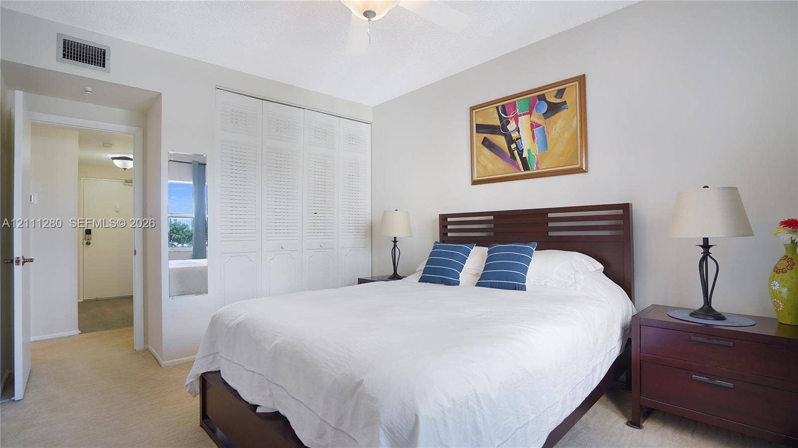 400 N Riverside Drive, #305, Pompano Beach, FL 33062 Interior space featuring wall-to-wall carpeting, floor-to-ceiling louvered closet doors, and a ceiling fan with integrated lighting