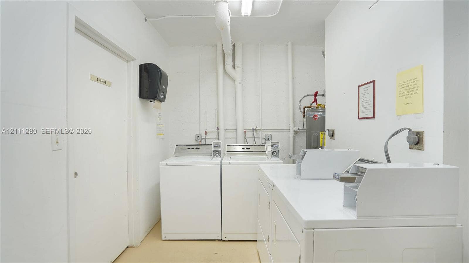 400 N Riverside Drive, #305, Pompano Beach, FL 33062 Laundry area featuring white appliances, a built-in folding counter, and a dedicated storage closet