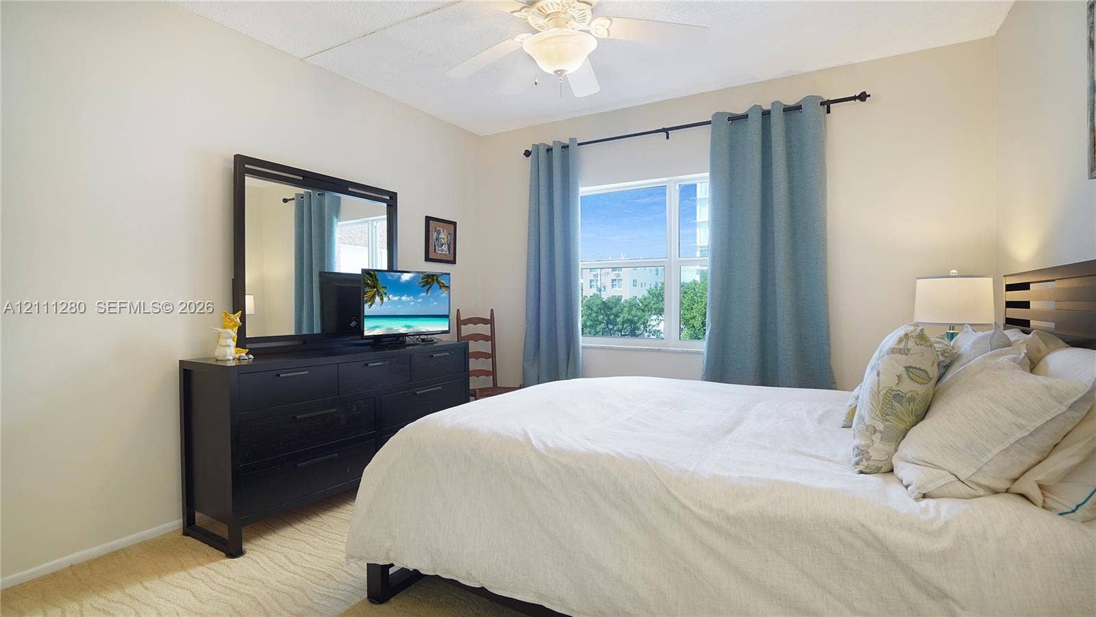400 N Riverside Drive, #305, Pompano Beach, FL 33062 Neutral-toned room featuring a central ceiling fan with an integrated light fixture and a large rectangular window