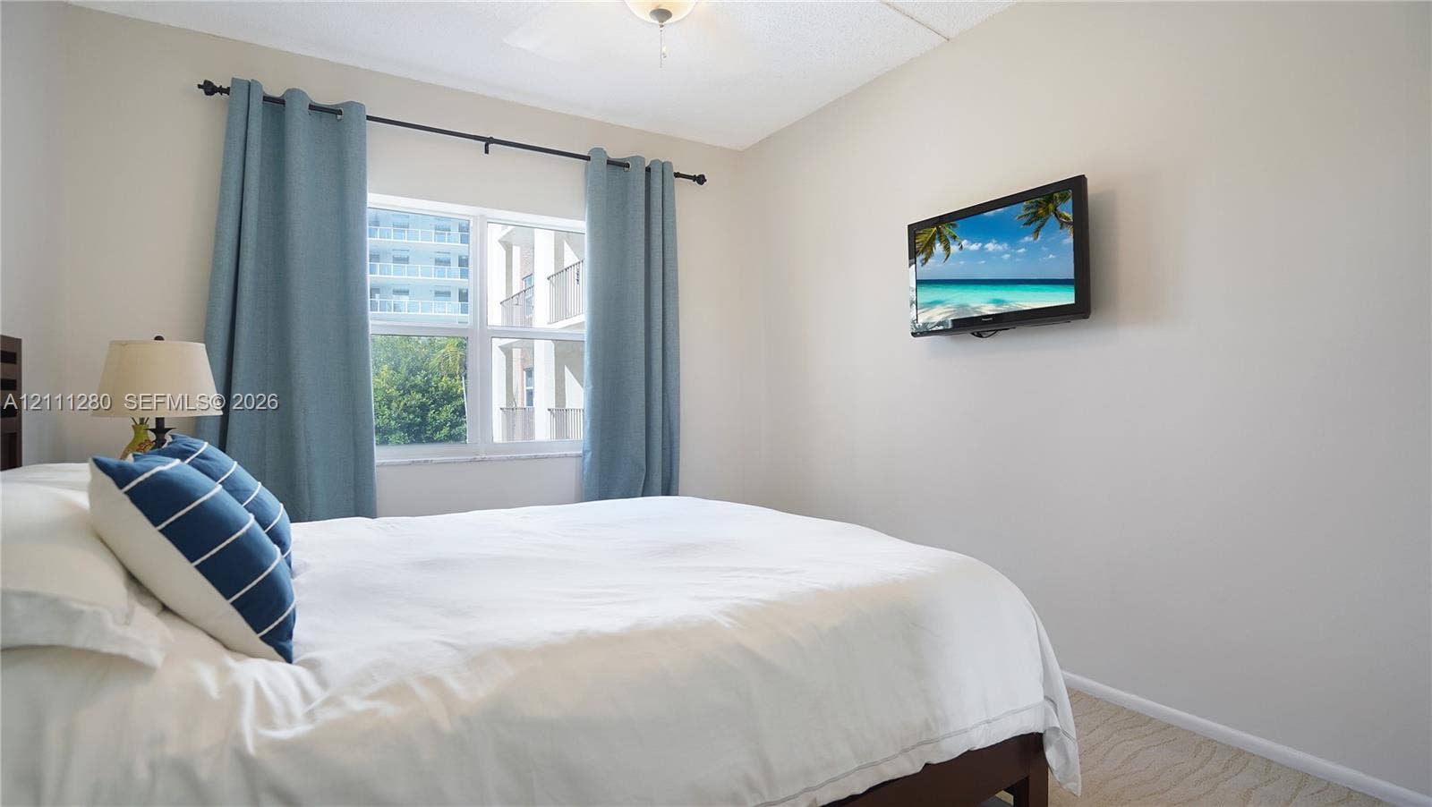 400 N Riverside Drive, #305, Pompano Beach, FL 33062 Neutral-toned interior featuring wall-to-wall carpeting, a dual-pane window, and a ceiling-mounted light fixture