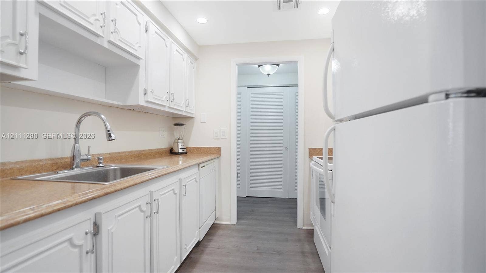 400 N Riverside Drive, #305, Pompano Beach, FL 33062 Kitchen featuring white cabinetry, stone-finish countertops, stainless steel sink with gooseneck faucet, recessed lighting, and wood-finish flooring
