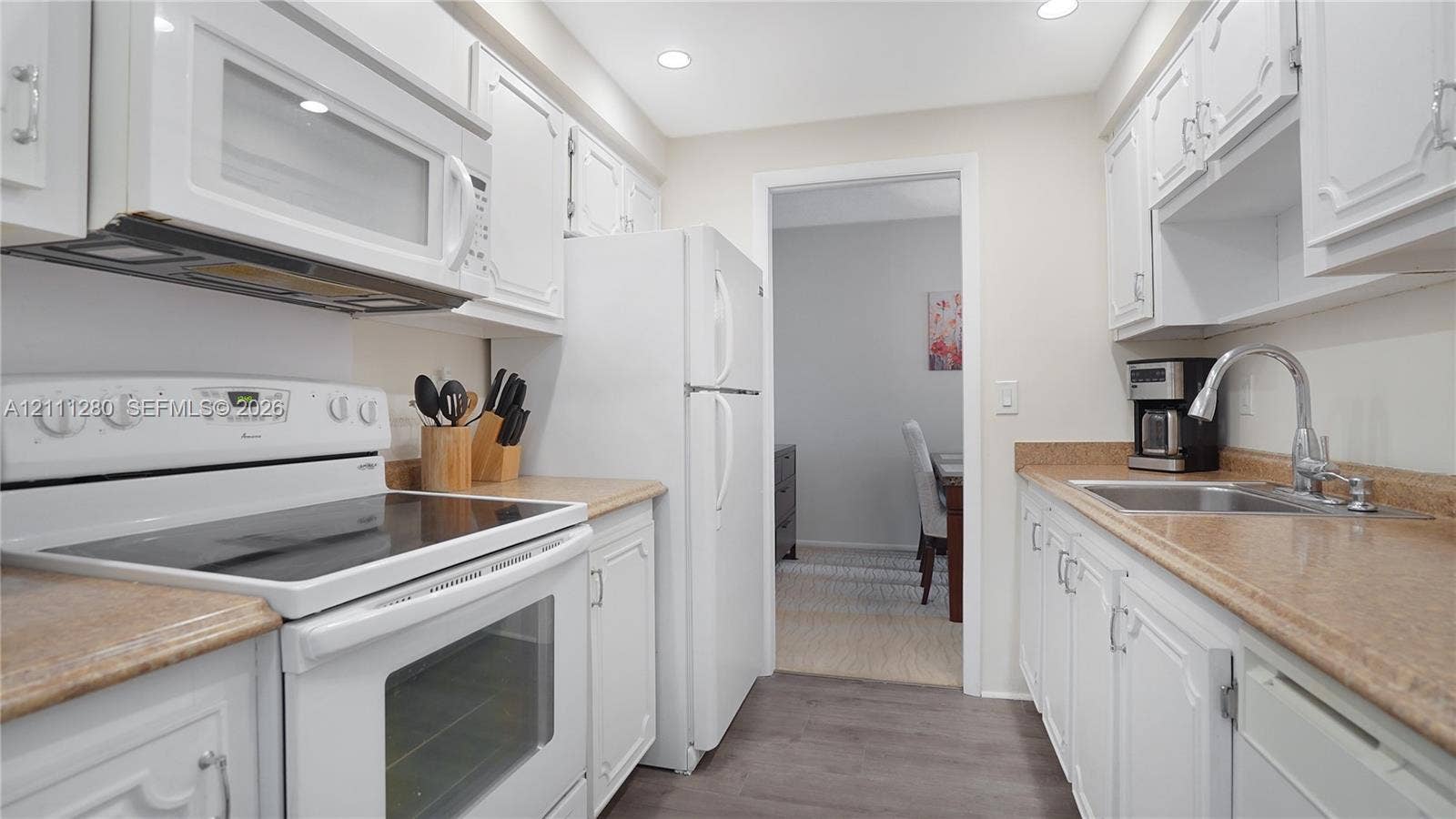 400 N Riverside Drive, #305, Pompano Beach, FL 33062 Kitchen featuring white cabinetry, solid-surface countertops, recessed lighting, and white appliances