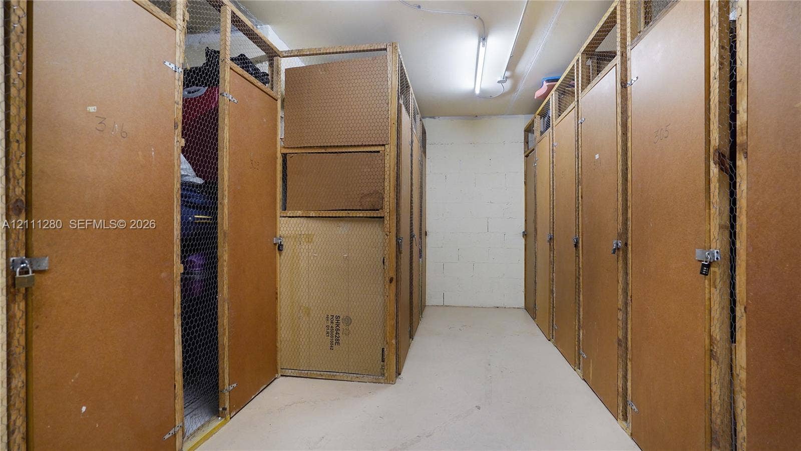 400 N Riverside Drive, #305, Pompano Beach, FL 33062 Dedicated storage area featuring enclosed wooden locker units with wire mesh paneling and secure padlock hasps