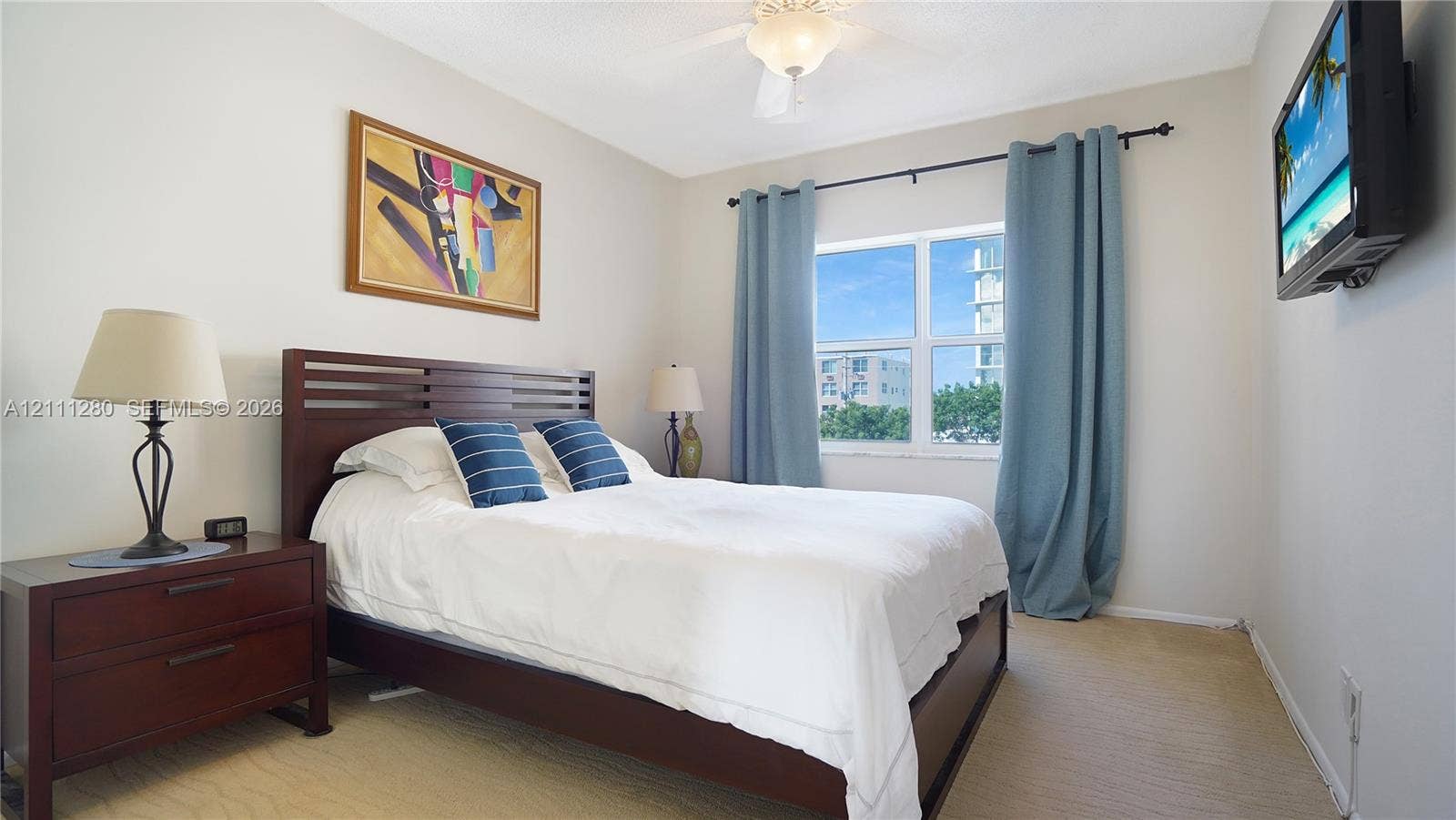 400 N Riverside Drive, #305, Pompano Beach, FL 33062 Neutral-toned room featuring a central ceiling fan with an integrated light fixture, carpeted flooring, and a multi-pane window