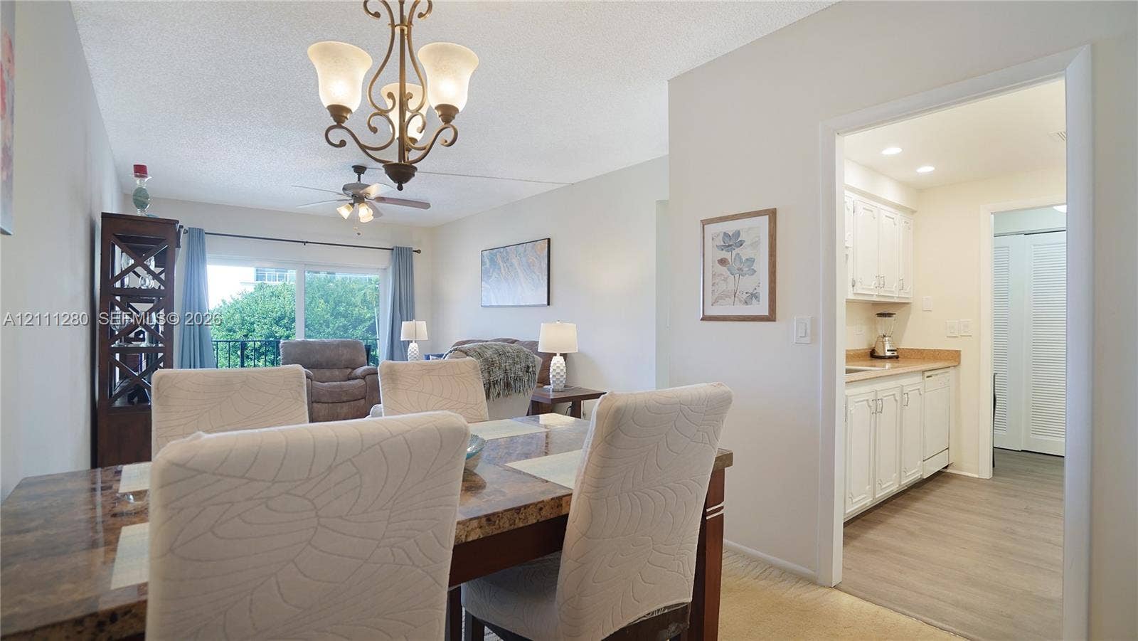 400 N Riverside Drive, #305, Pompano Beach, FL 33062 Dining area featuring a classic iron chandelier, wood-finish flooring, and sliding glass doors