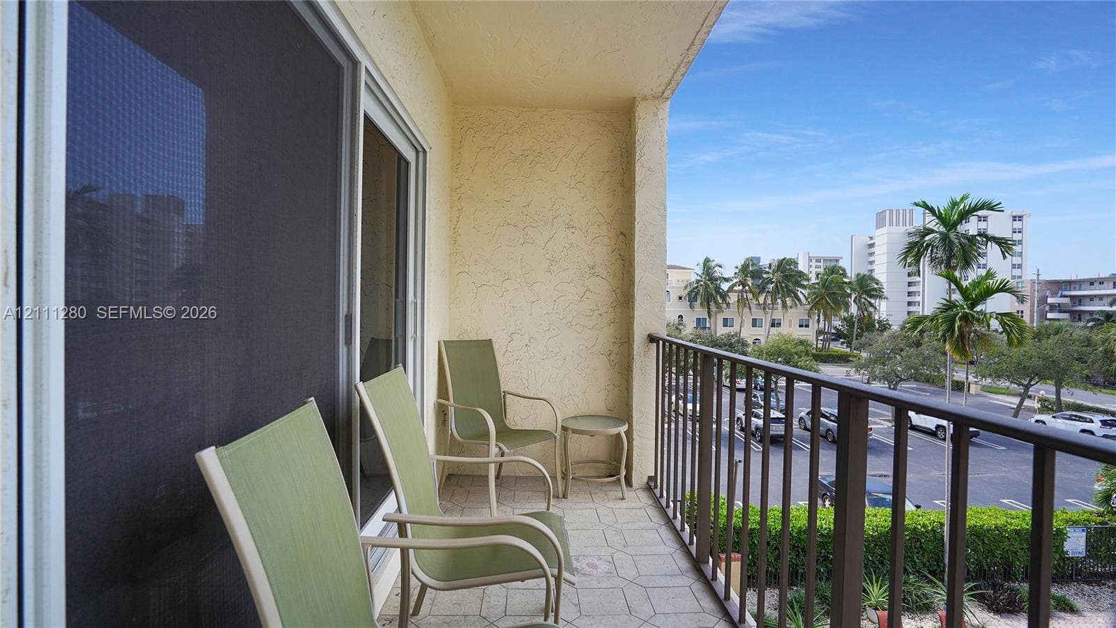 400 N Riverside Drive, #305, Pompano Beach, FL 33062 Covered balcony featuring a textured stucco wall, tile flooring, and metal railing
