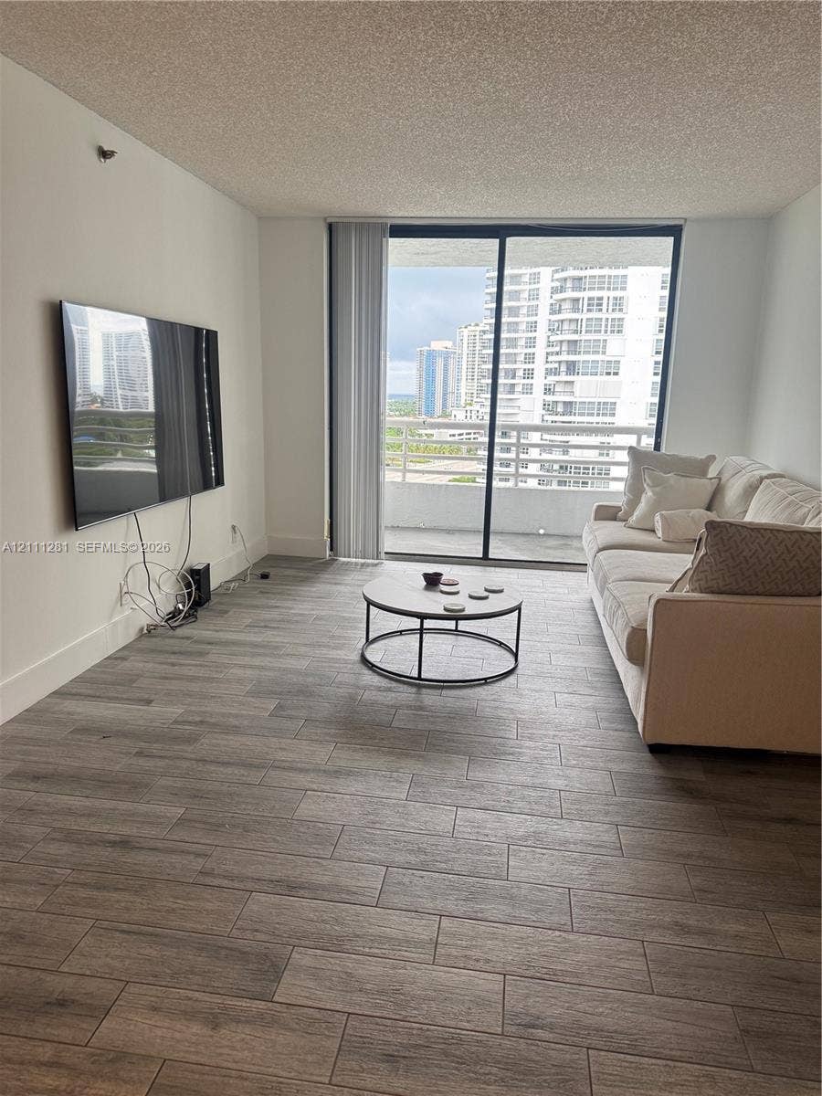 Living area featuring porcelain-finish flooring and large sliding glass doors opening to a private balcony