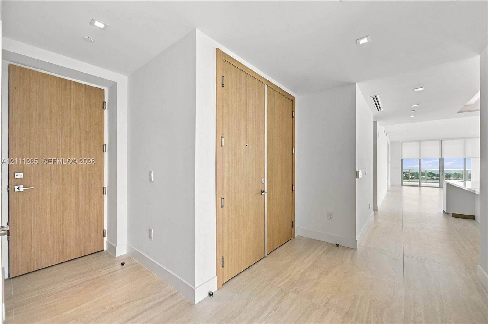 Solid wood-finish doors, large-format tile flooring, and recessed ceiling lighting