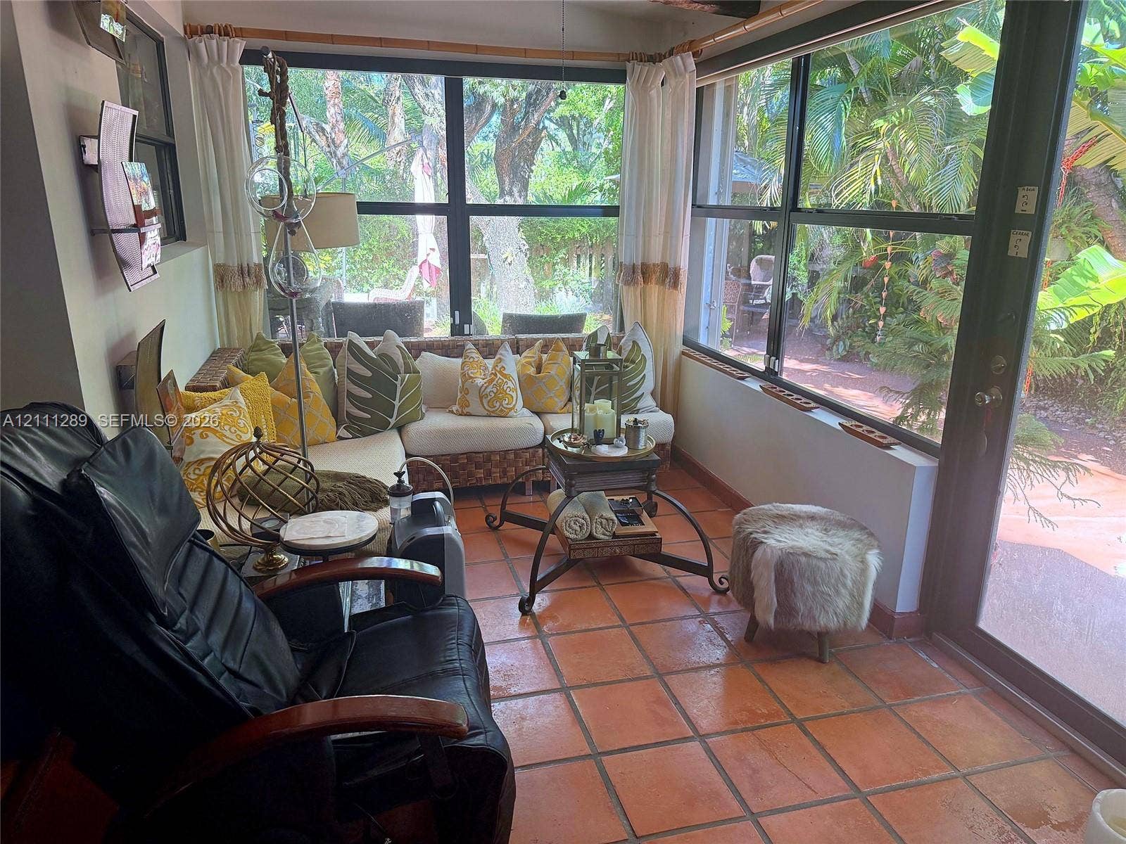 Sunroom featuring ceramic tile flooring, floor-to-ceiling windows, and a glass-paneled door