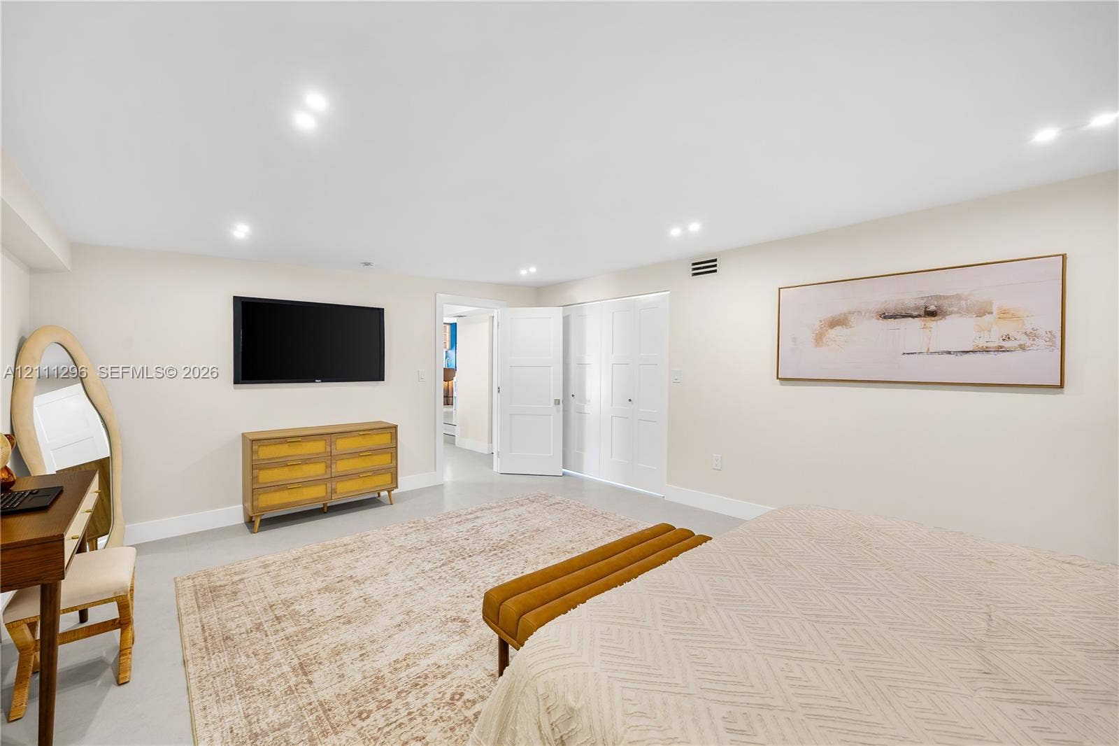 Neutral-toned walls, recessed lighting, and closet doors with recessed panels