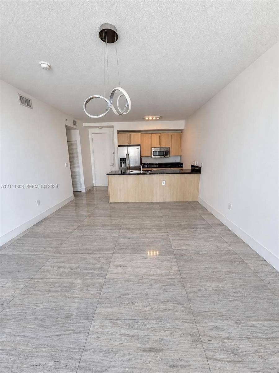 1111 SW 1st Avenue, #2324-N, Miami, Miami, FL 33130 Large-format tile flooring, flat-panel light-finish cabinetry, dark solid-surface countertops, and contemporary circular chandelier lighting