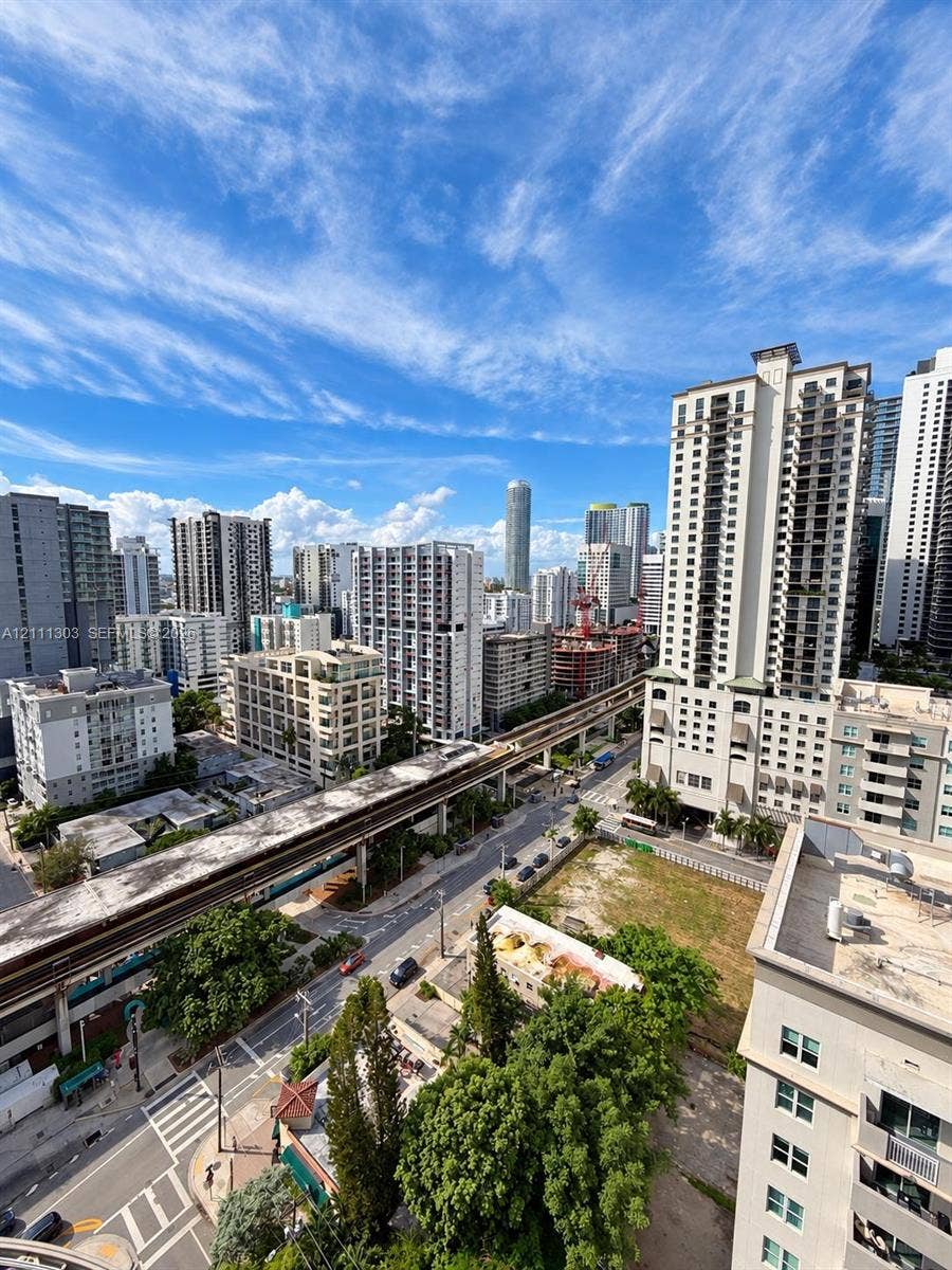 1111 SW 1st Avenue, #2324-N, Miami, Miami, FL 33130 High-rise perspective featuring an urban cityscape, elevated rail infrastructure, and multi-story residential architecture