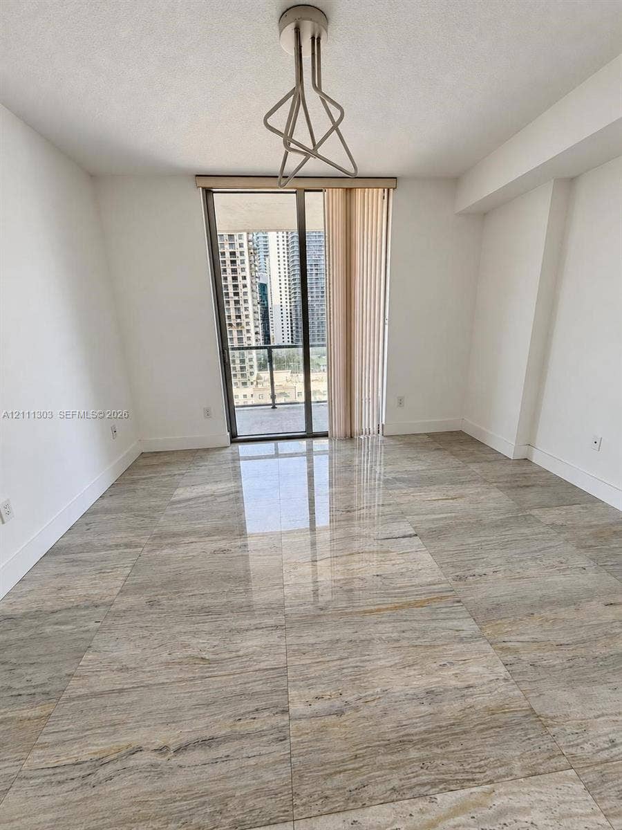 1111 SW 1st Avenue, #2324-N, Miami, Miami, FL 33130 Polished stone flooring, geometric metal pendant lighting, and floor-to-ceiling glass sliding doors leading to a private balcony
