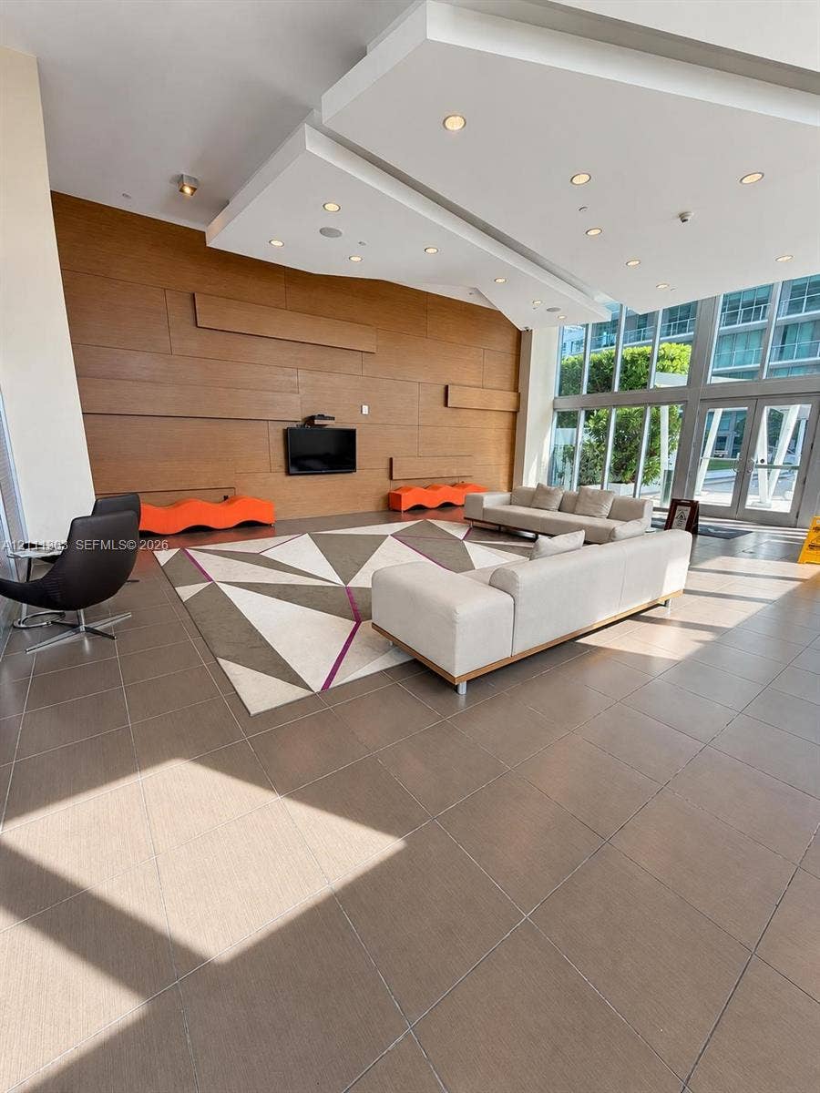 1111 SW 1st Avenue, #2324-N, Miami, Miami, FL 33130 Lobby area featuring wood-panel accent wall, tile flooring, recessed ceiling lighting, and floor-to-ceiling glass windows