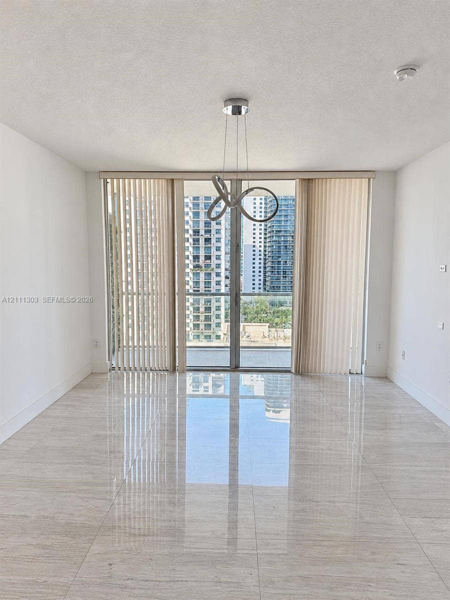 1111 SW 1st Avenue, #2324-N, Miami, Miami, FL 33130 Polished stone-finish flooring, floor-to-ceiling glass sliding doors, private balcony, and a contemporary sculptural pendant light fixture