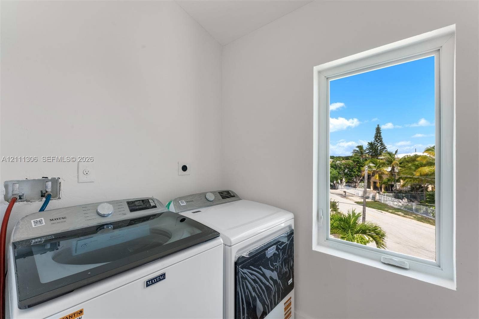 Laundry room featuring a vaulted ceiling and a window providing exterior natural light
