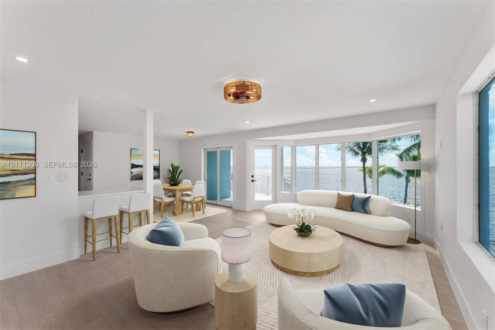 Open-concept living space featuring wood-finish flooring, recessed lighting, a breakfast bar, and expansive windows with water scenery