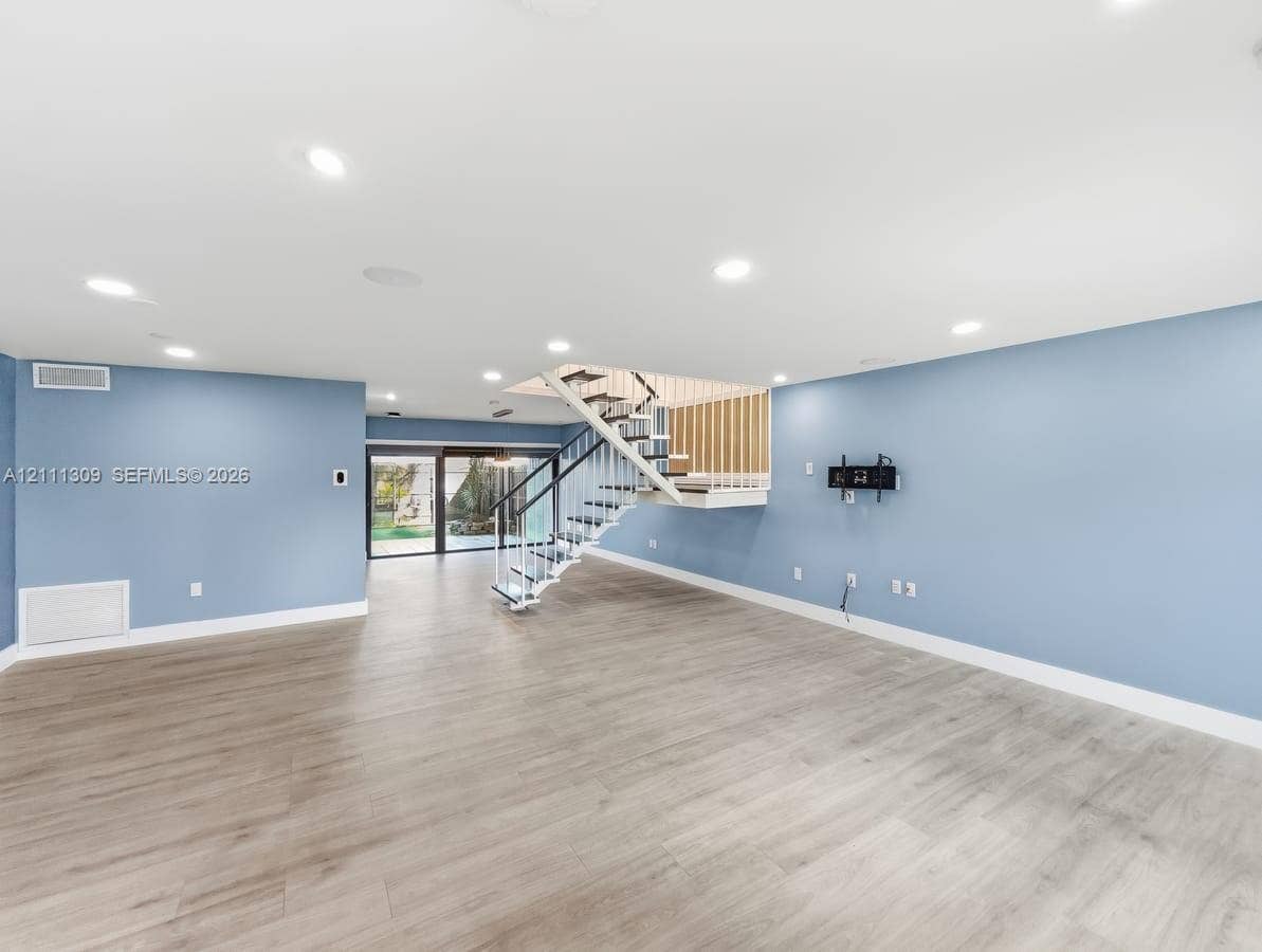 6518 Kendale Lakes Drive, #809, Miami, Miami, FL 33183 Open interior space featuring wood-finish flooring, recessed lighting, and a staircase with a black metal railing and wooden balusters