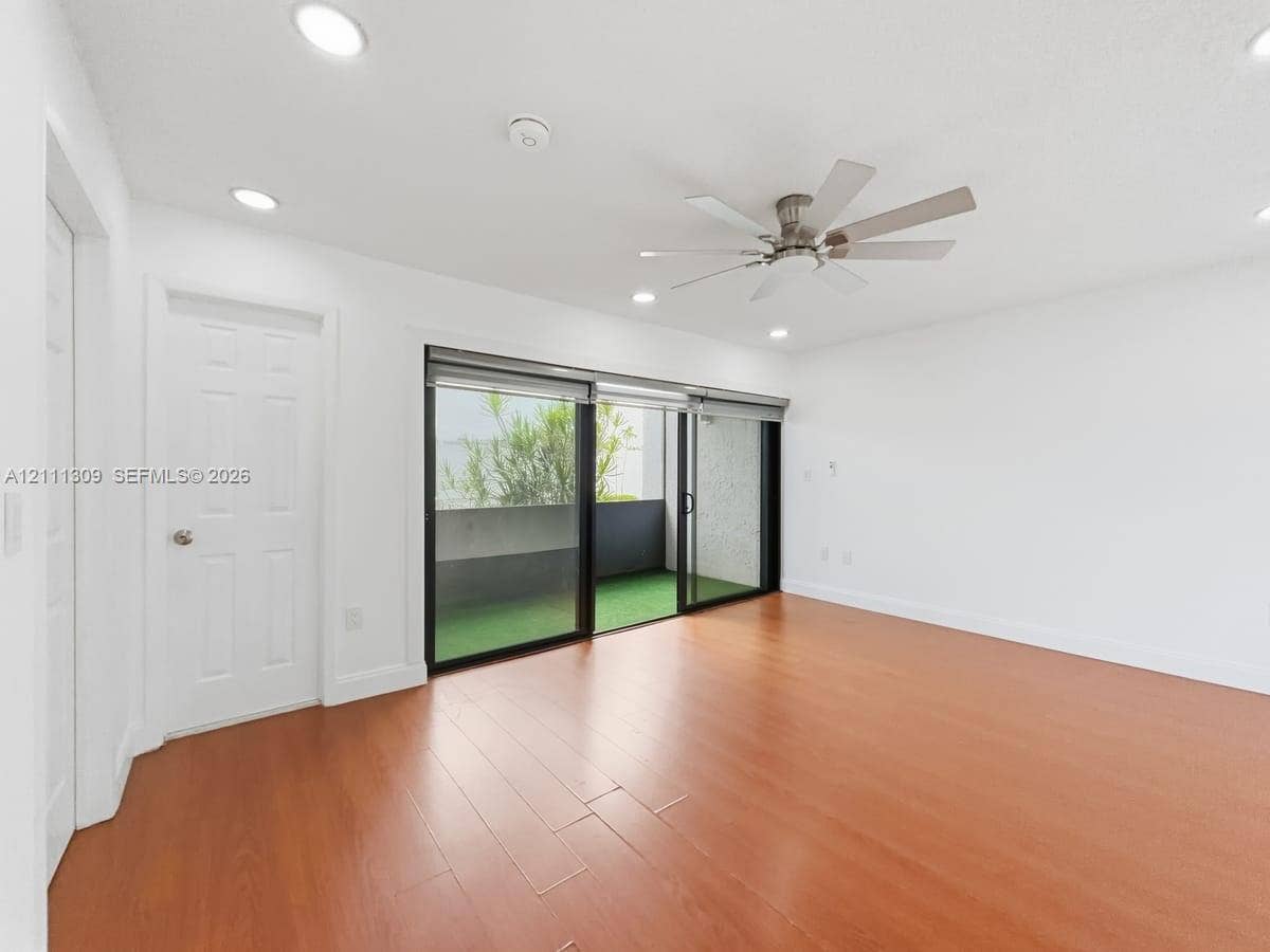 6518 Kendale Lakes Drive, #809, Miami, Miami, FL 33183 Interior space featuring wood-finish flooring, recessed lighting, a multi-blade ceiling fan, and sliding glass doors providing access to an exterior balcony