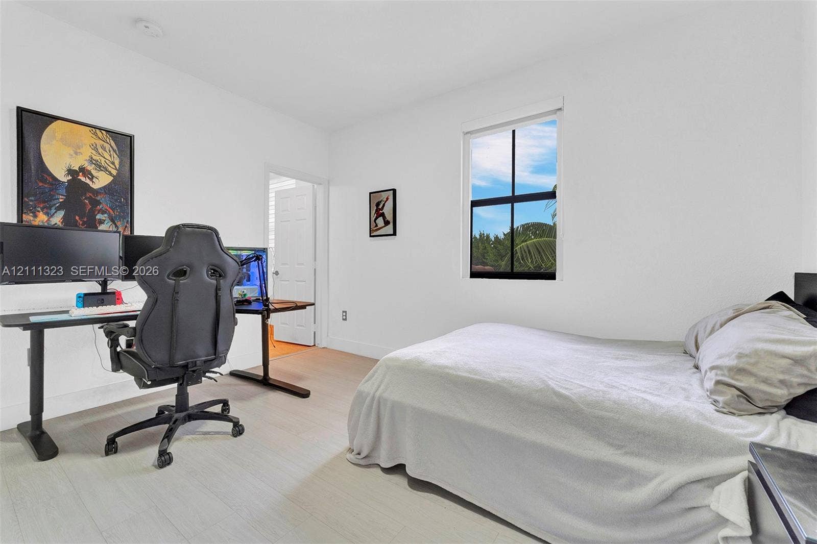 Neutral wall finishes, wood-finish flooring, and a window with a black frame