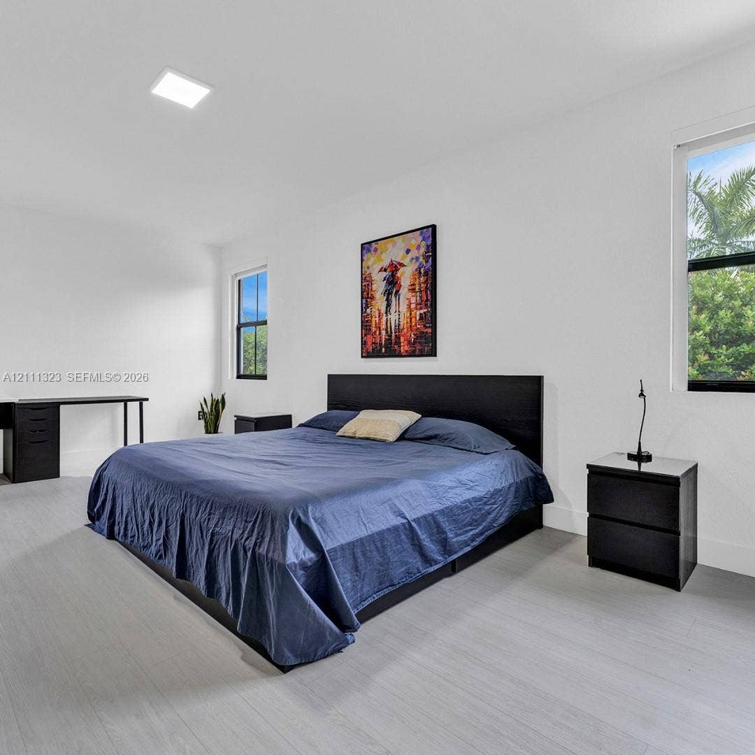 Neutral wall finishes, light wood-finish flooring, and recessed ceiling lighting
