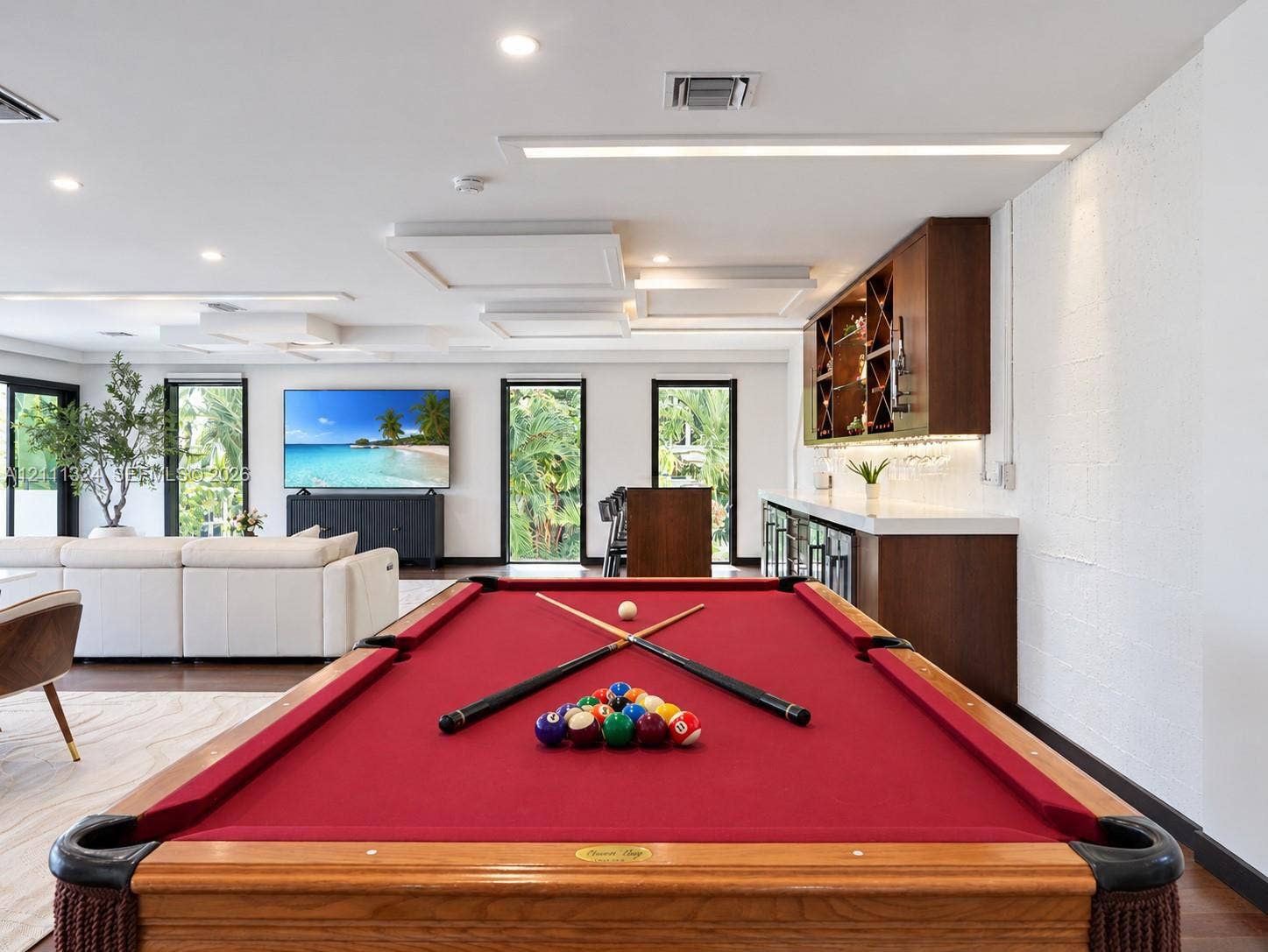 Custom built-in bar featuring wood cabinetry, stone countertops, and glass-front storage shelving