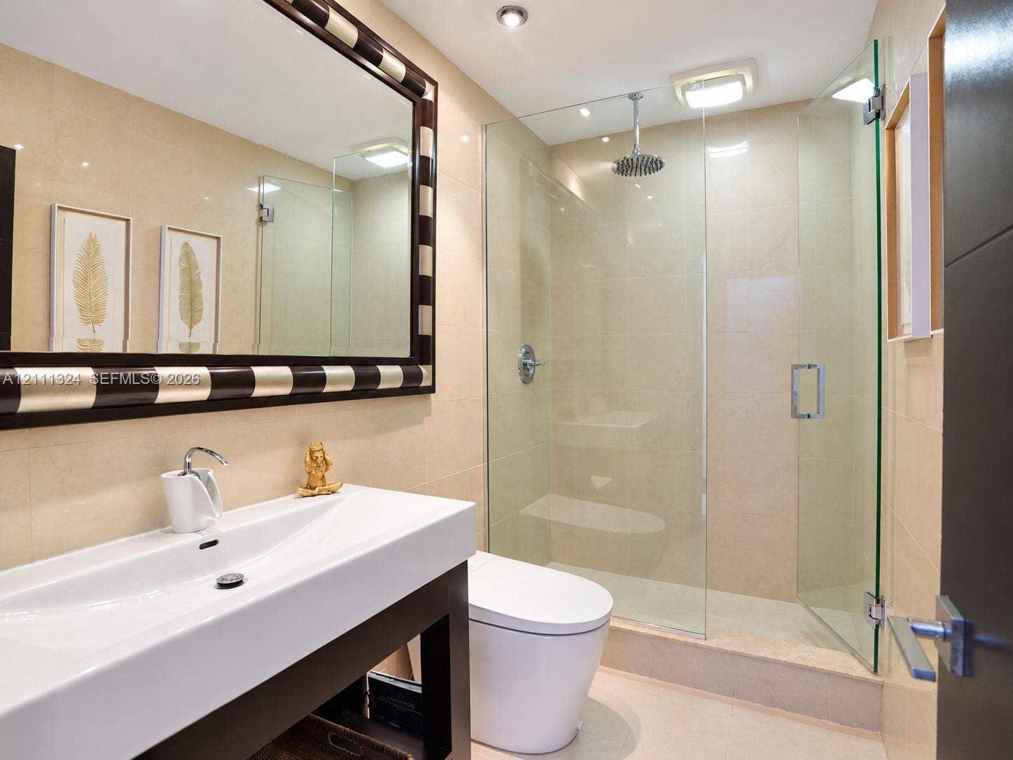 Bathroom featuring a wall-mounted vanity with integrated sink, walk-in glass-enclosed shower with rain-style showerhead, and recessed lighting