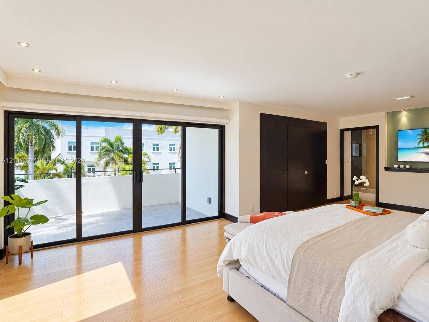 Interior space featuring wood-finish flooring, recessed lighting, floor-to-ceiling sliding glass doors, a built-in recessed media niche, and dark wood-finish cabinetry