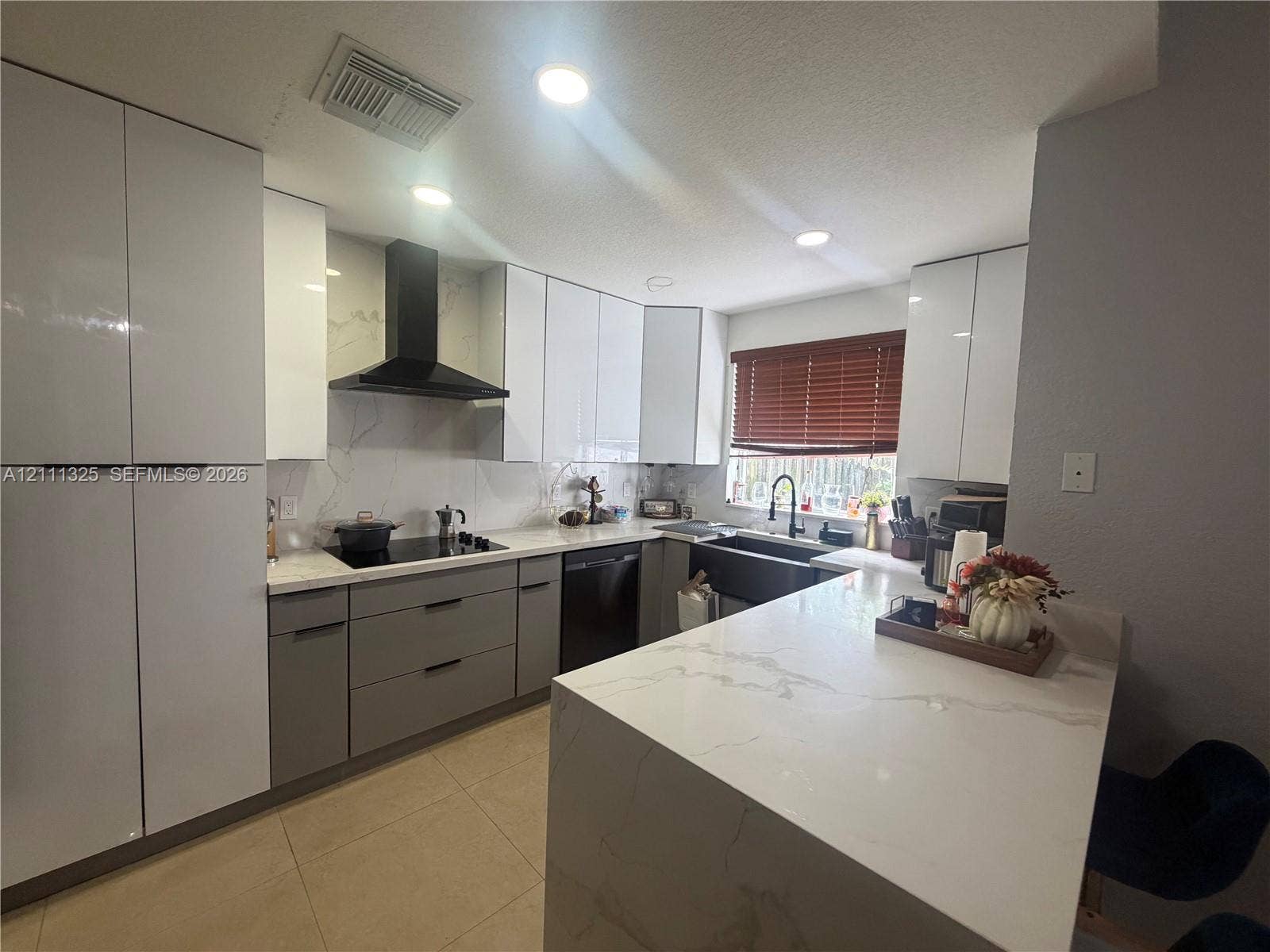 18172 SW 108th Path, Miami, Miami, FL 33157 Kitchen featuring flat-panel cabinetry, light-toned stone-finish countertops, a farmhouse-style sink, a matte black range hood, and recessed lighting