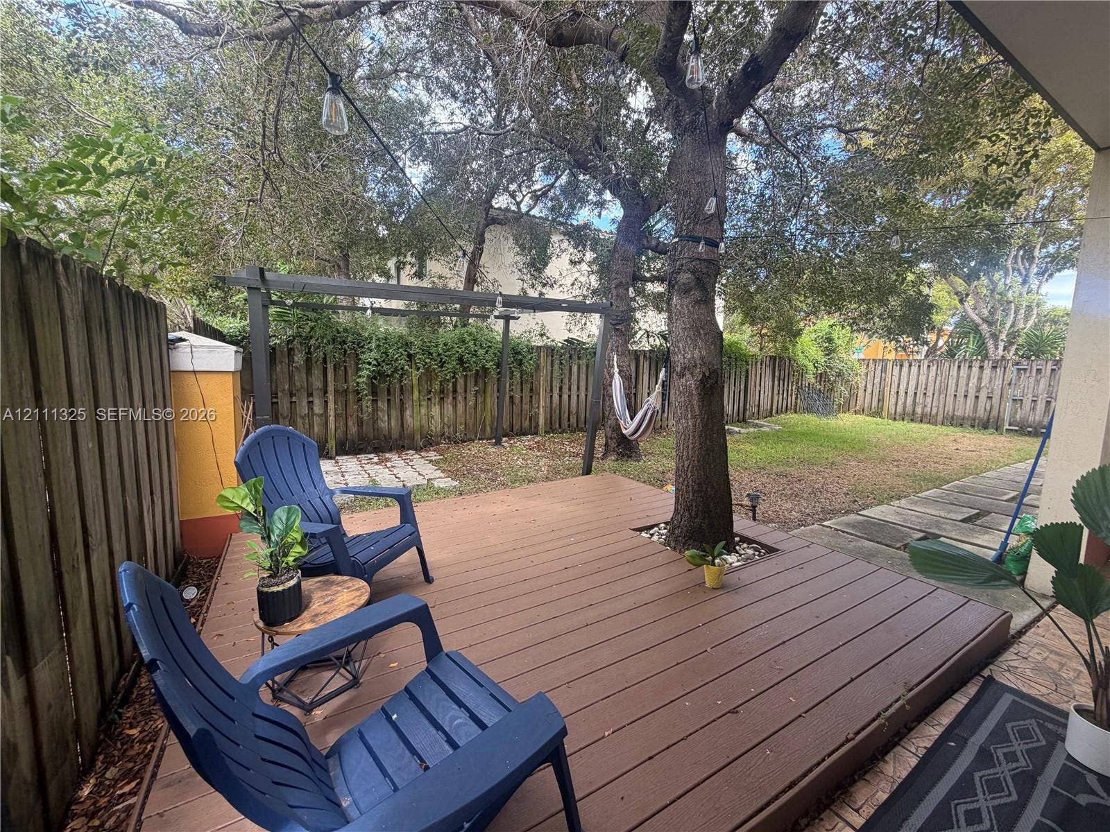 18172 SW 108th Path, Miami, Miami, FL 33157 Backyard featuring a wood-finish deck, mature trees, a metal pergola, and a privacy fence