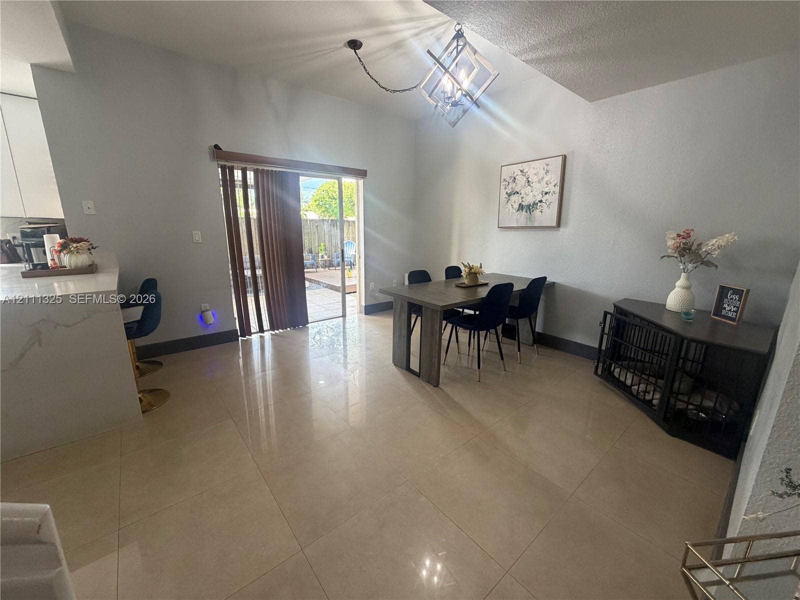 18172 SW 108th Path, Miami, Miami, FL 33157 Large-format tile flooring, vaulted ceiling with geometric metal chandelier, and sliding glass patio door