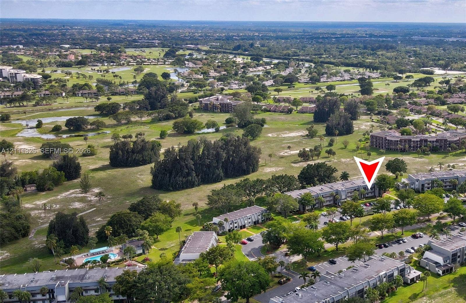 4801 Esedra Court, #207, Lake Worth, FL 33467 Aerial perspective of the community with a red arrow indicating the location of the unit.