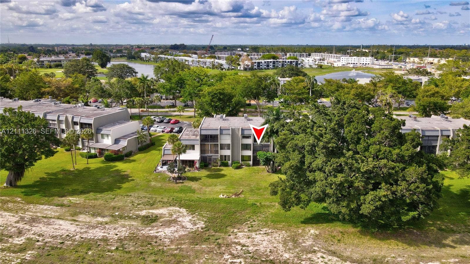 4801 Esedra Court, #207, Lake Worth, FL 33467 Aerial exterior view from the back of the unit looking North featuring balconies, concrete exterior siding, and expansive surrounding green space with mature landscaping.